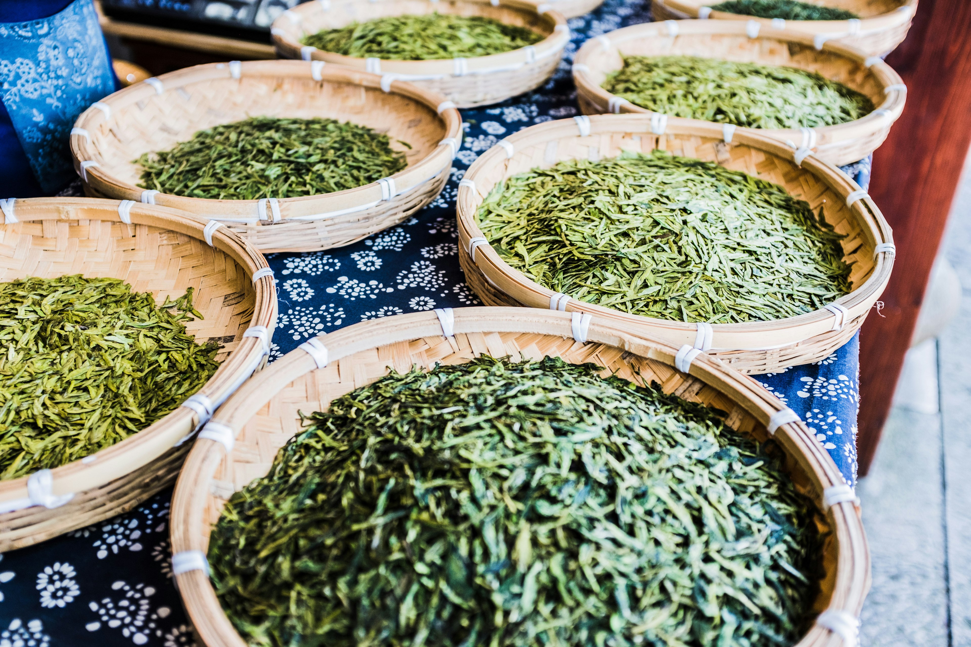 Several open baskets filled with drying tea leaves