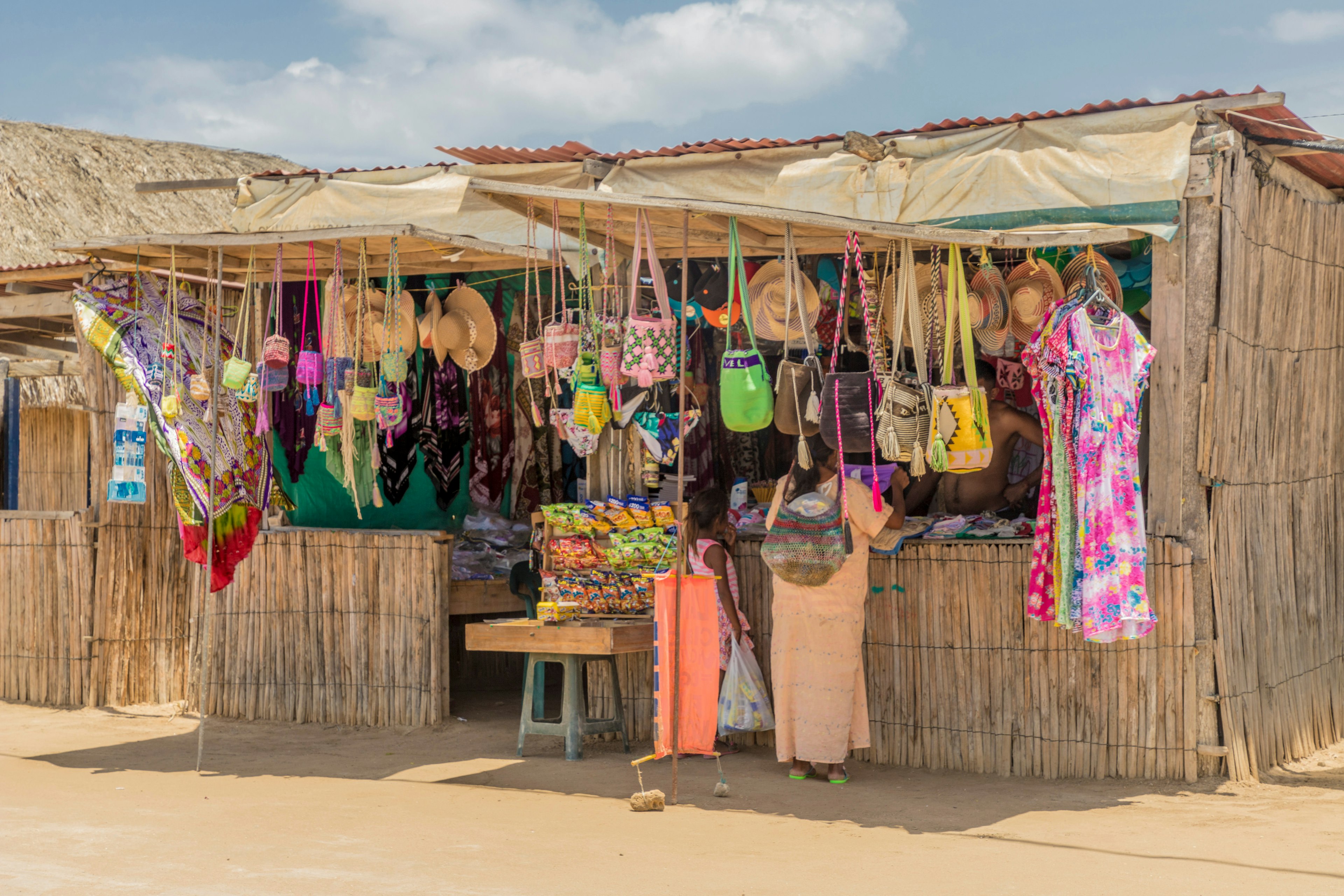 A woman and child stand in a handicraft shop made of reeds in La Guajira, Colombia