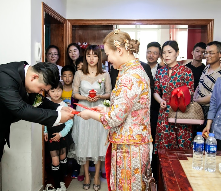 A Chinese groom giving his bride a red envelope from her mother-in-law