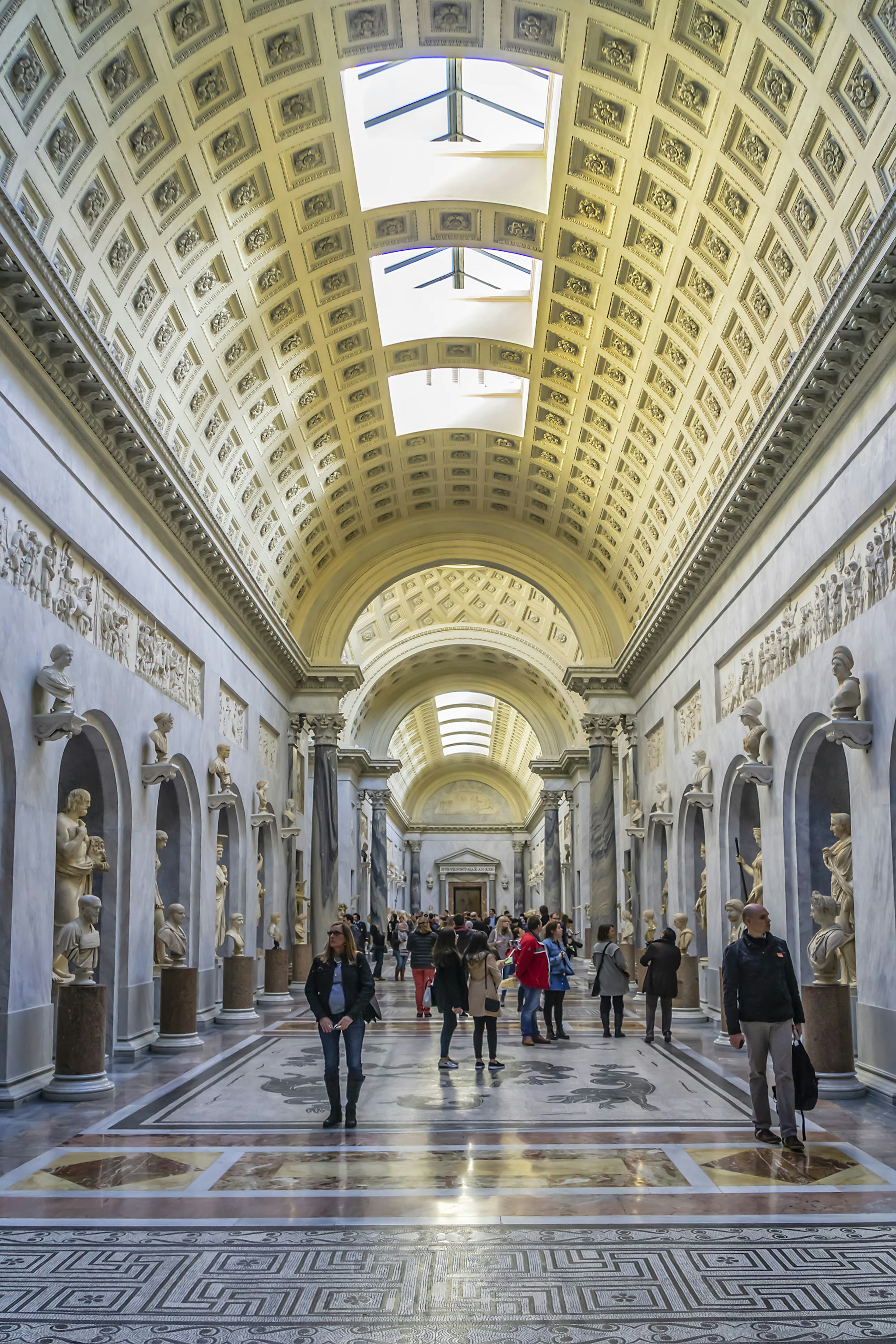 Visitors at the Gallery of Statues and Hall of Busts inside the Pio-Clementine Museum