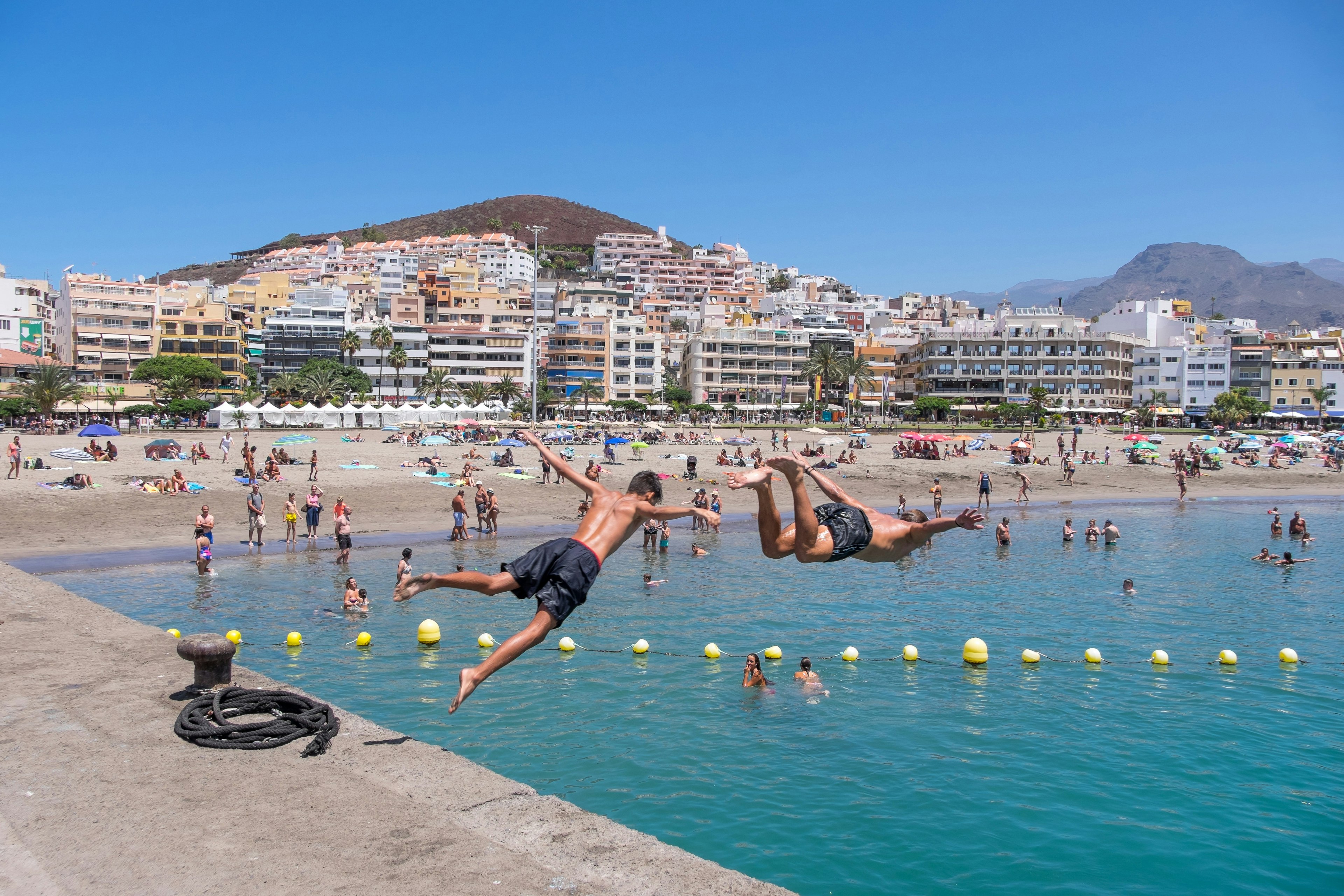 July 25, 2019: Young boys jumping into the water from the port of Los Cristianos.
1465537337
africa, atlantic, beach, blue, boat, building, buildings, canary islands, city, coast, coastline, destination, editorial, europe, fish boat, harbor, harbour, holiday, island, landscape, nature, outdoor, people, port, resort, sand, sea, ship, sky, spain, spanish, summer, sunny, tenerife, tourism, touristic, town, transport, transportation, travel, vacation, view, village, water