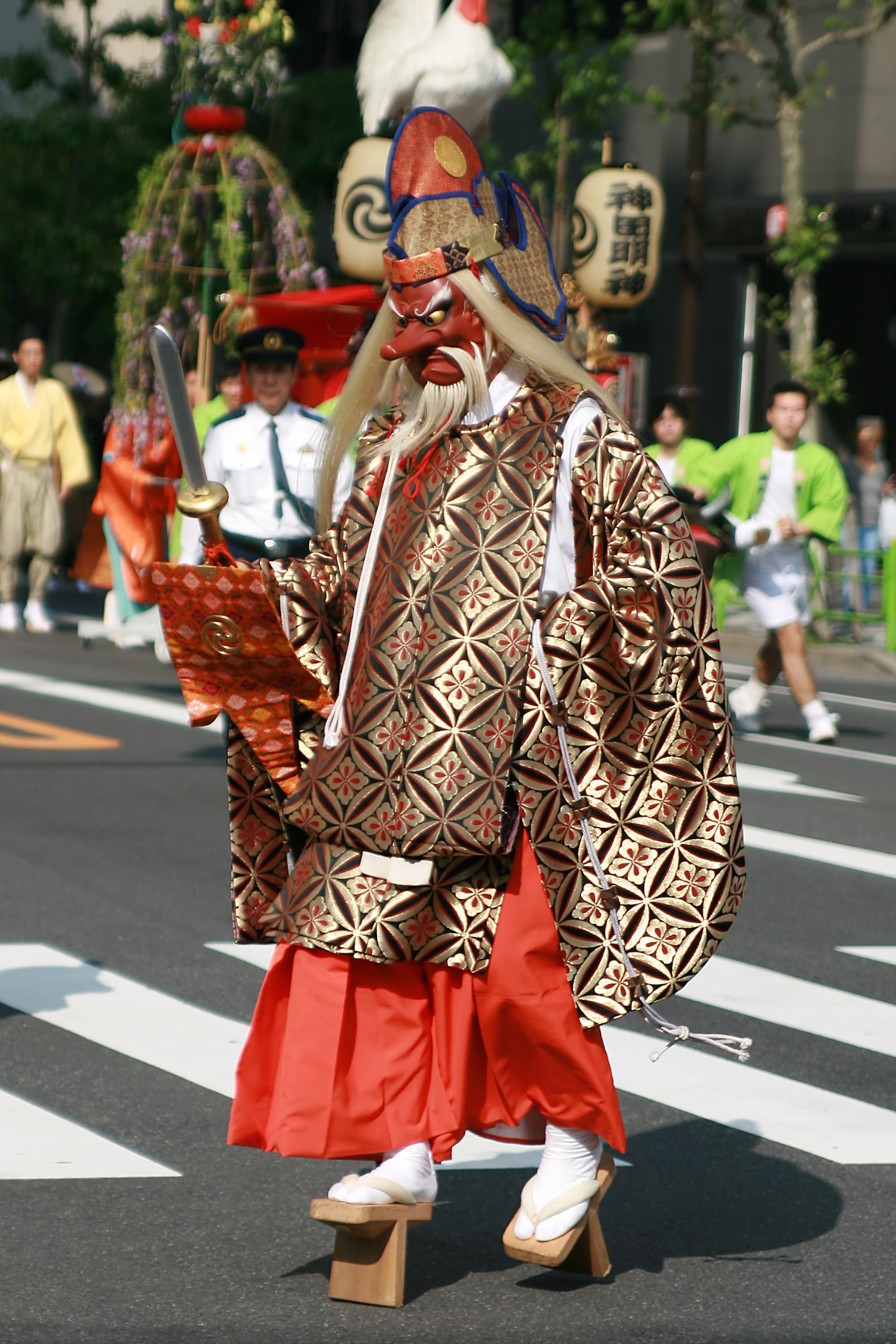 A traditional character from Japan, a tengu, walks in the street