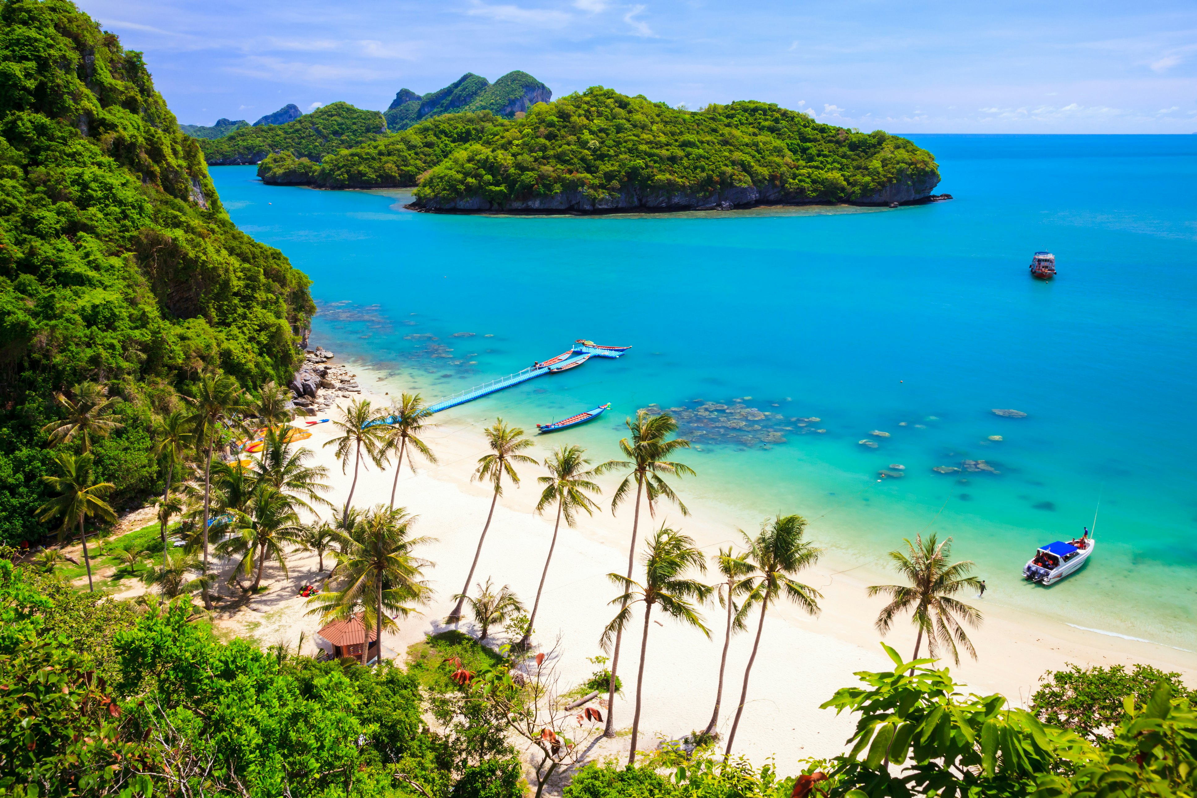 Boats in a turquoise cove in Ang Thong National Marine Park, Koh Samui, Thailand.
