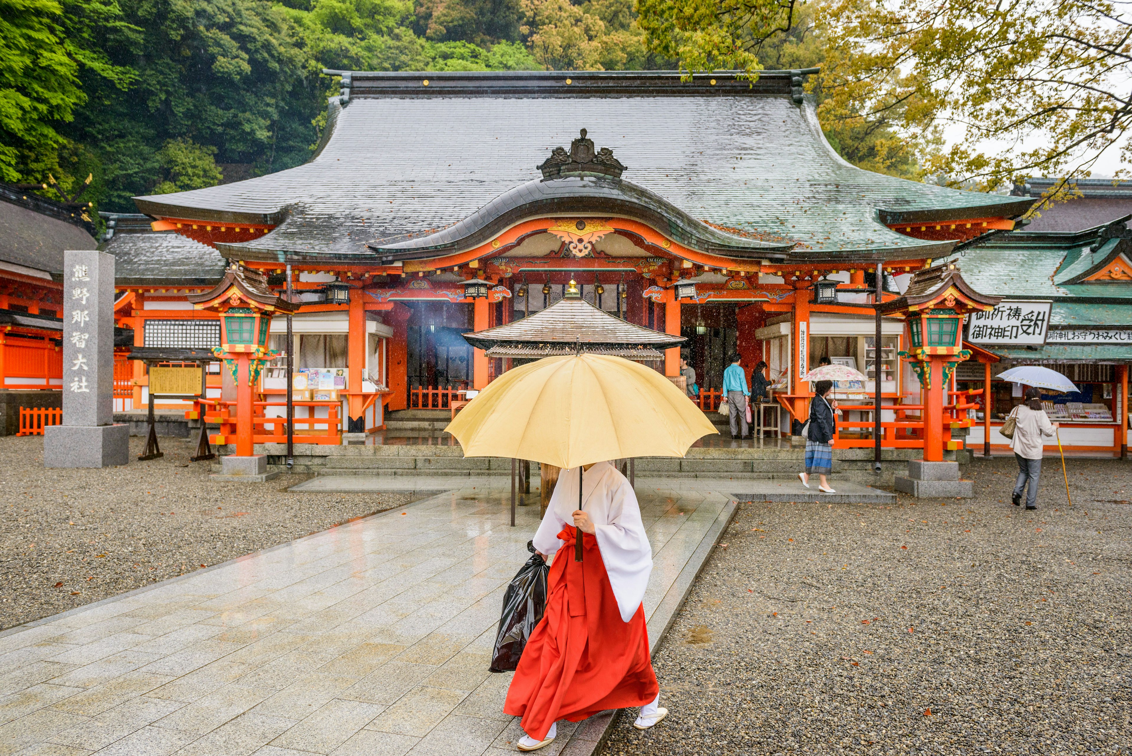 A shinto priest and tourists at Kumano Nachi Taisha Shrine's Heiden hall. The Temple is a World Heritage Site.