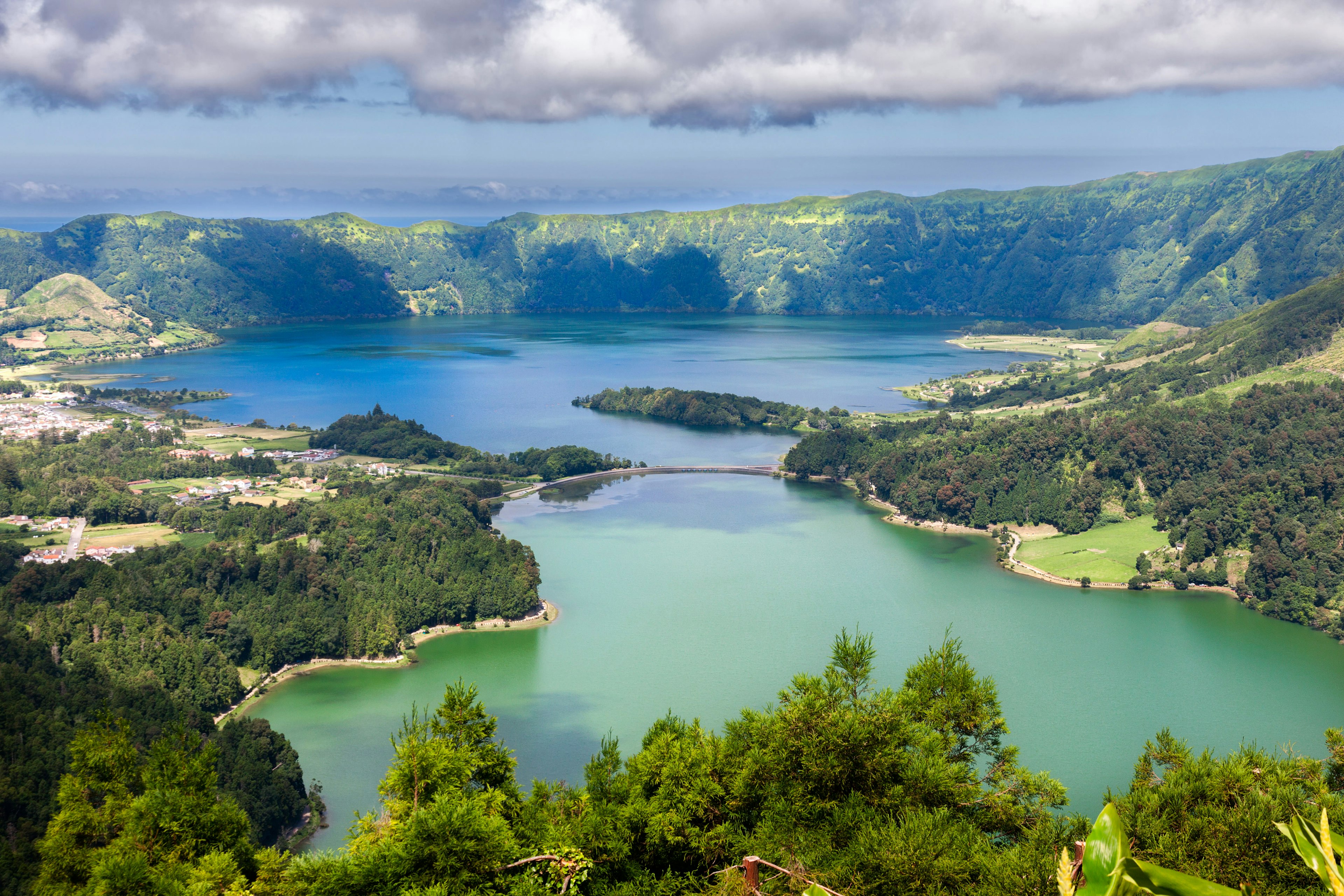 A series of clouds overlooks twin blue and green lakes of Lake  Sete Cidades from Vista do Rei viewpoint in Sao Miguel, Azores.