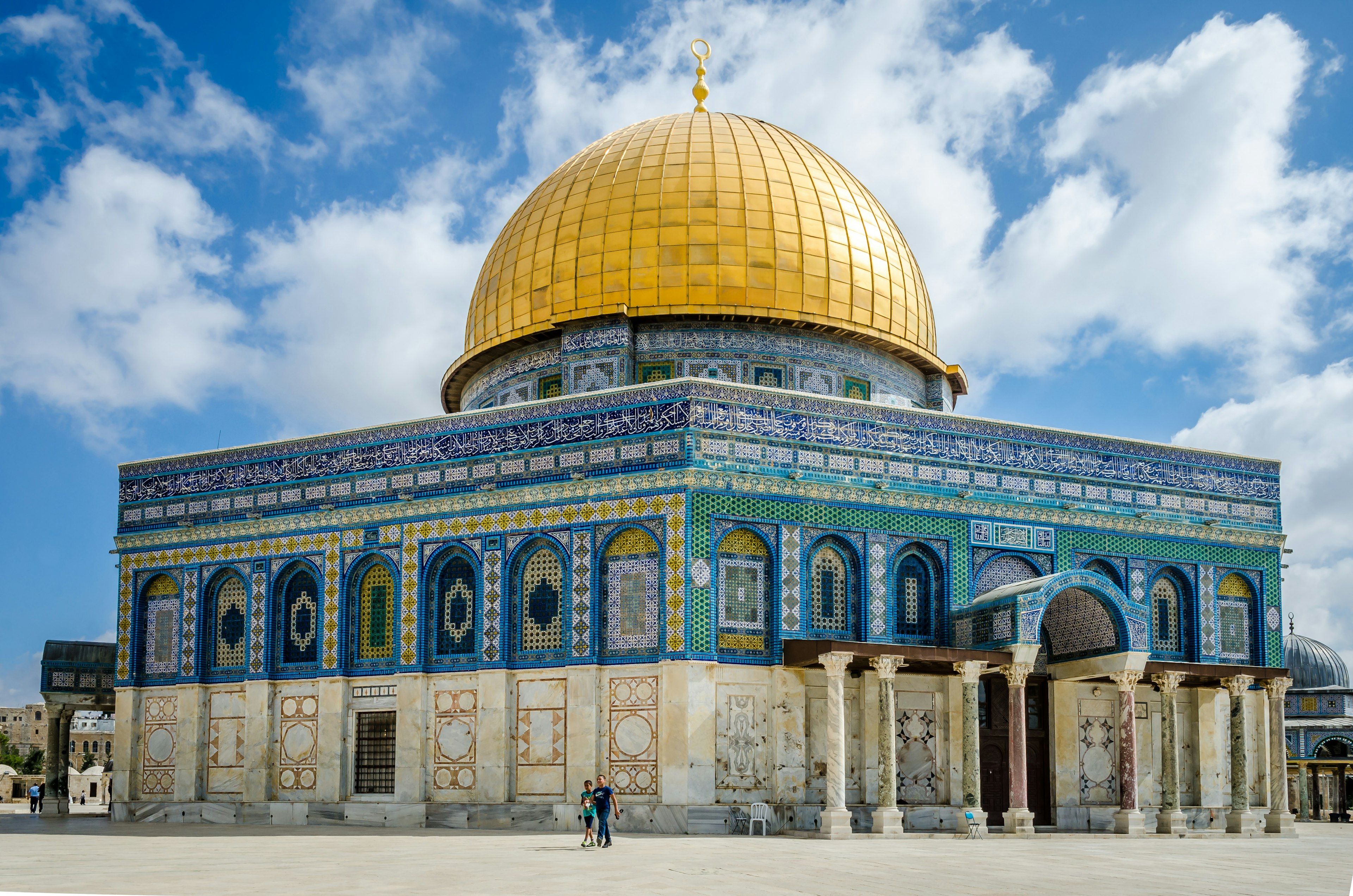 People walk past the Dome of the Rock on the Temple Mount.