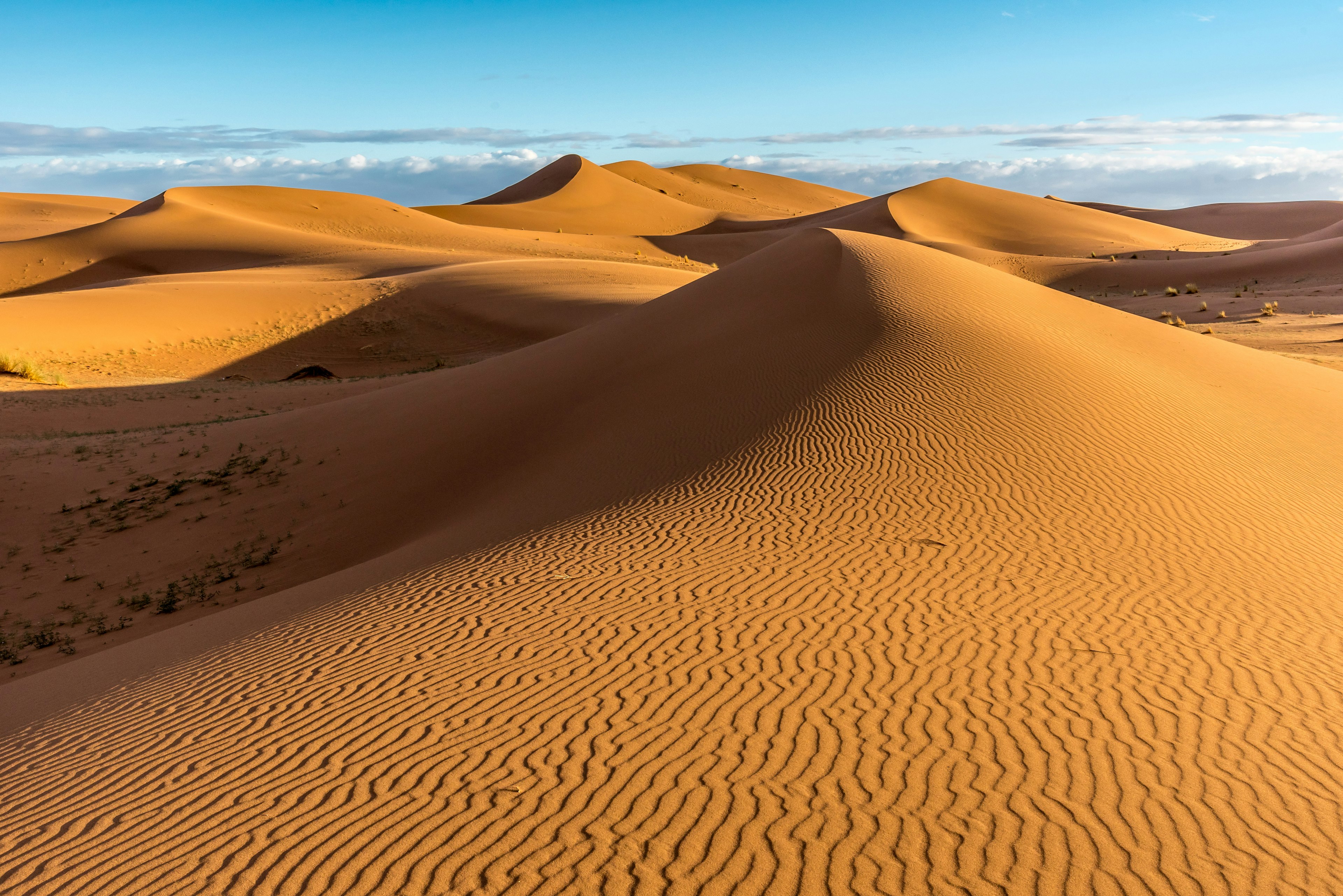 Empty sand dunes in Erg Chigaga with blue sky.