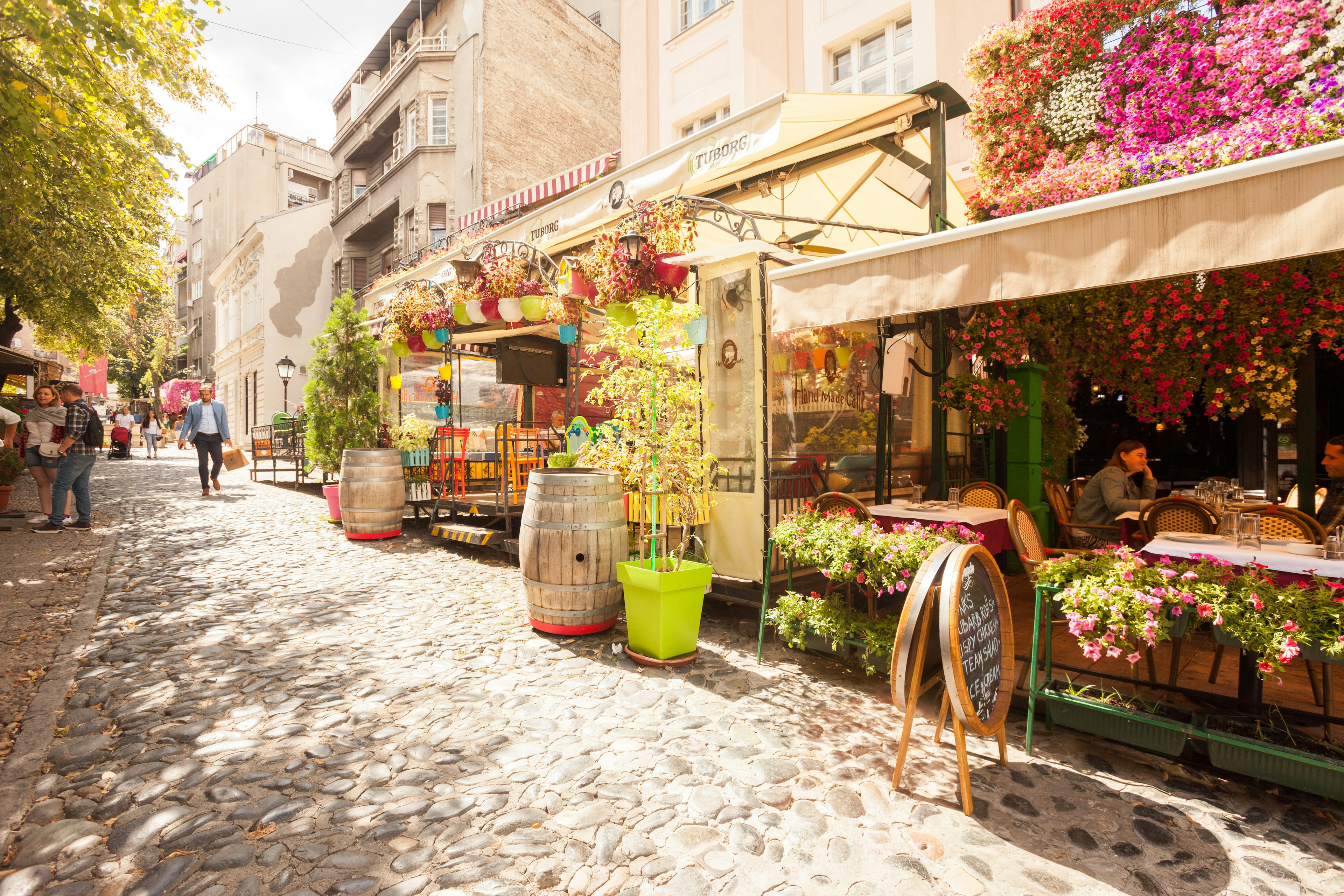 Cafes with tables along a cobbled street in Belgrade