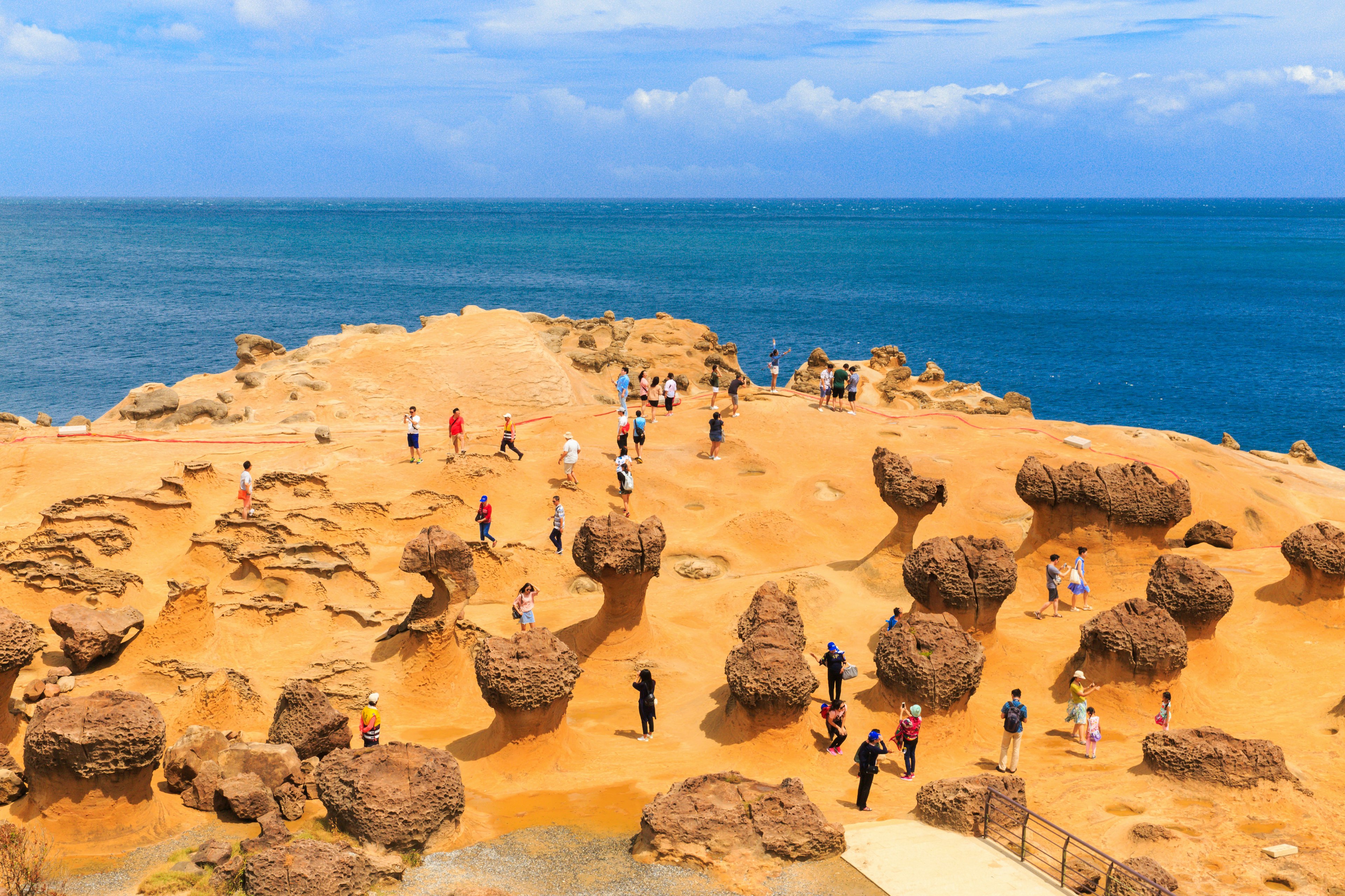 Tourists explore the mushroom rocks by the sea at the Yehliu Geopark.