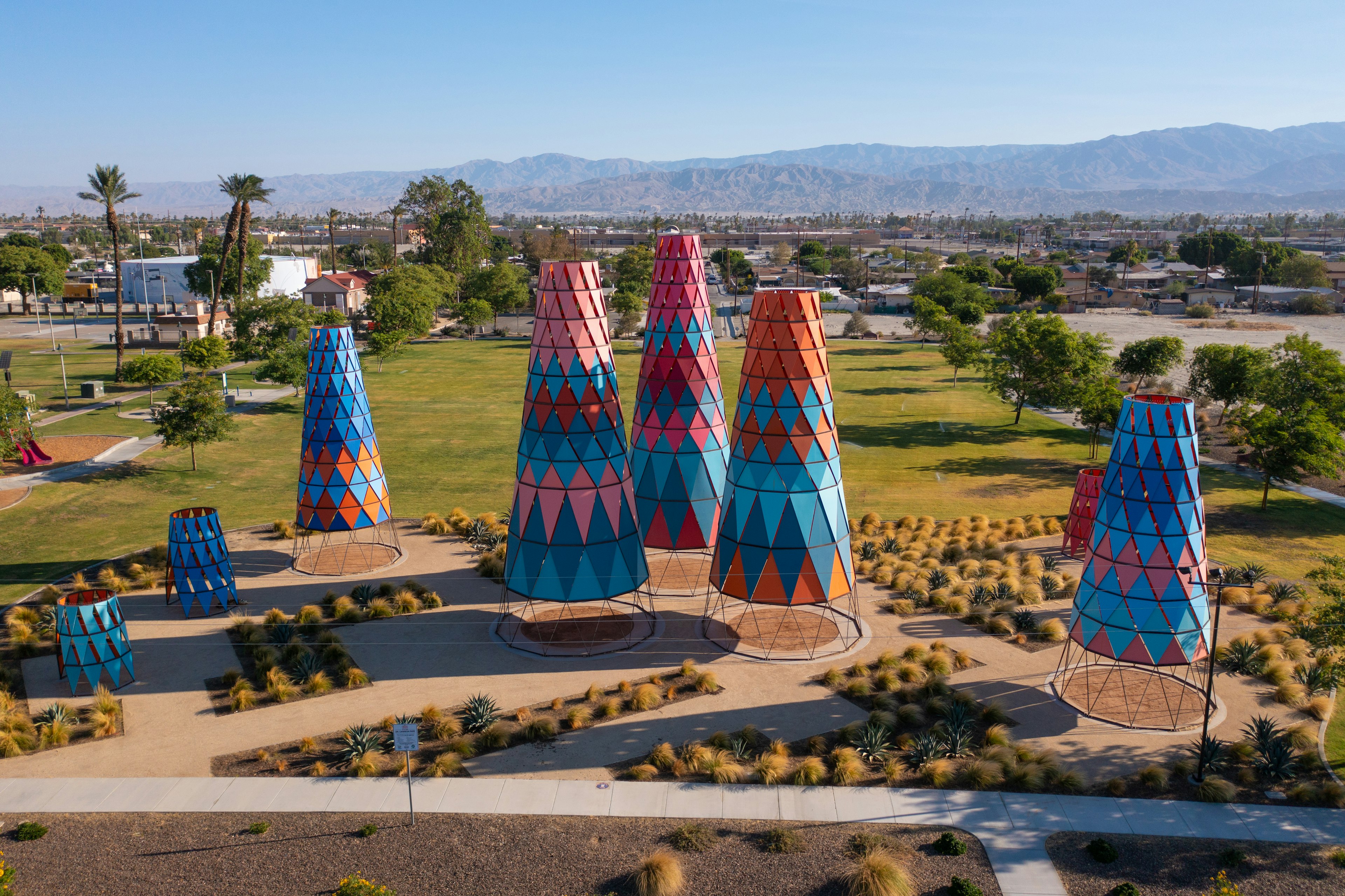 Nine giant multicolored cones stand in an art installation