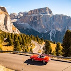 Driving with red convertible car in the Dolomites mountains during autumn season
1061872058