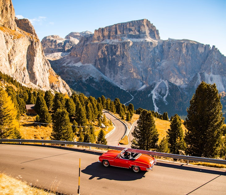 Driving with red convertible car in the Dolomites mountains during autumn season
1061872058