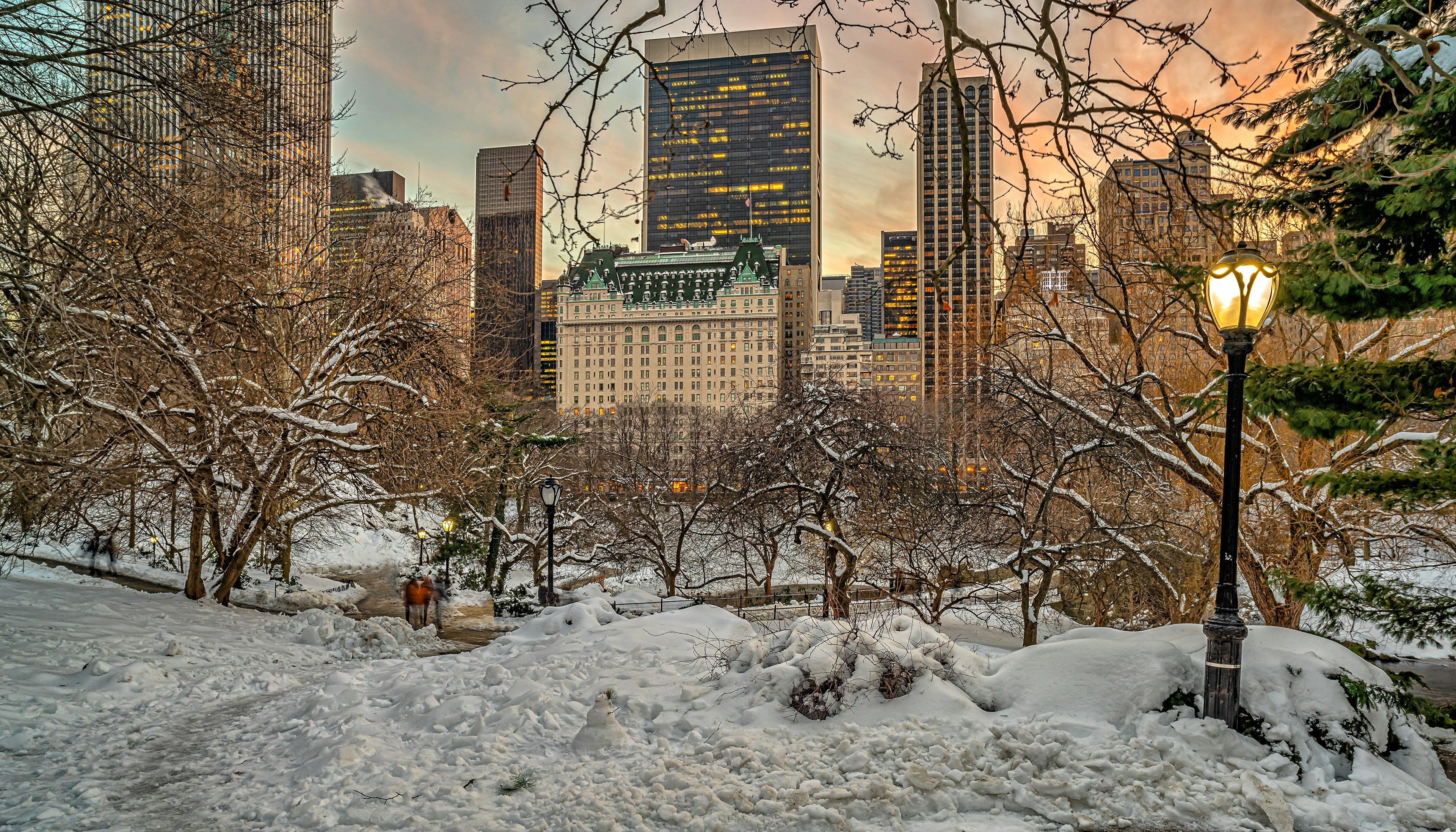 A large art deco-style hotel on the edge of a snow-covered park