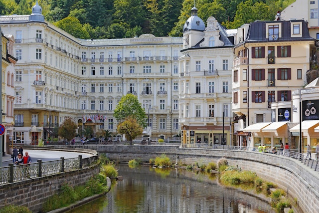 The ornate, white-facaded Grandhotel Pupp on the river Tepla River.