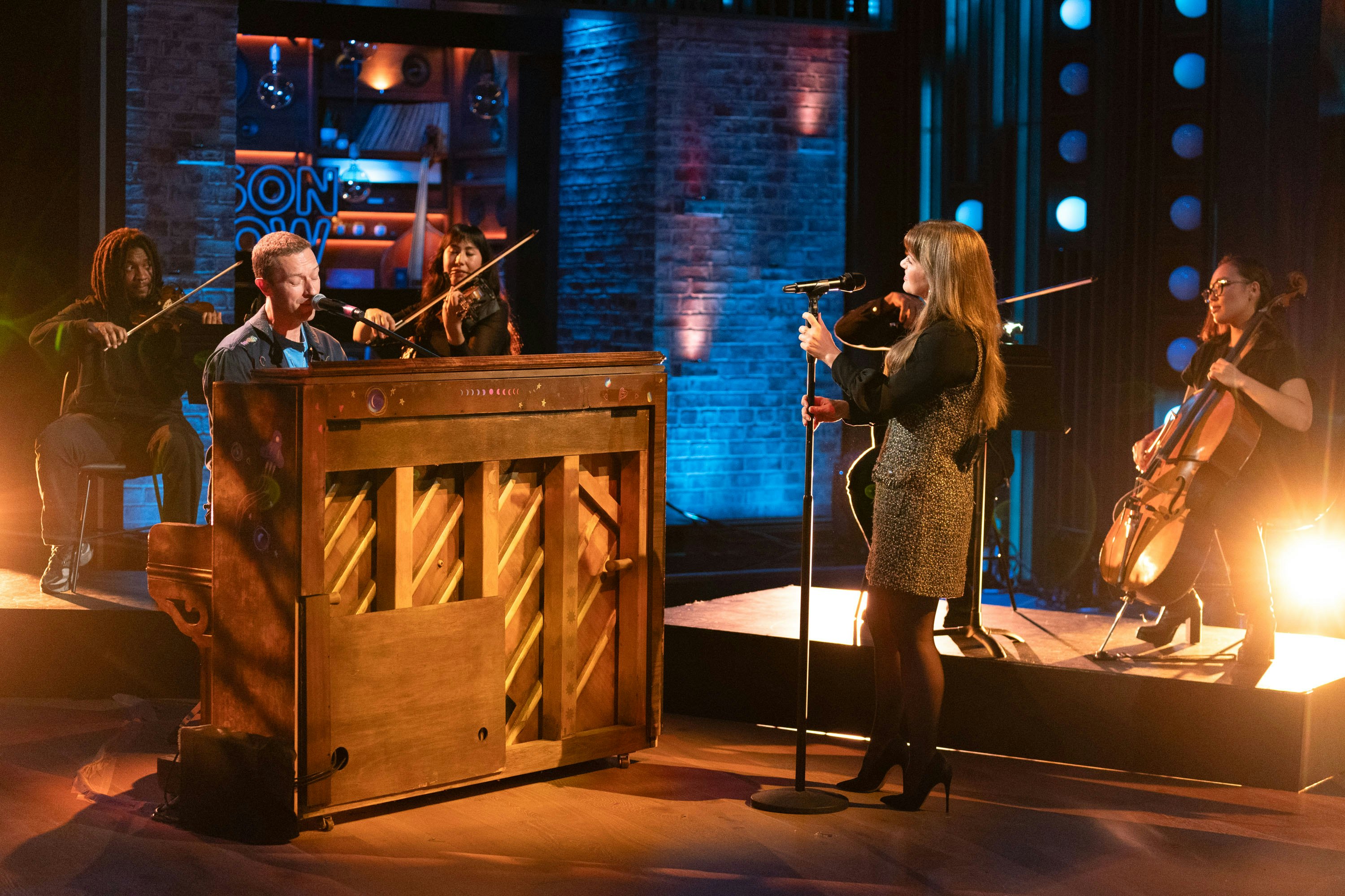 A pianist (Chris Martin from Coldplay) performs with a singer (the TV show host Kelly Clarkson)