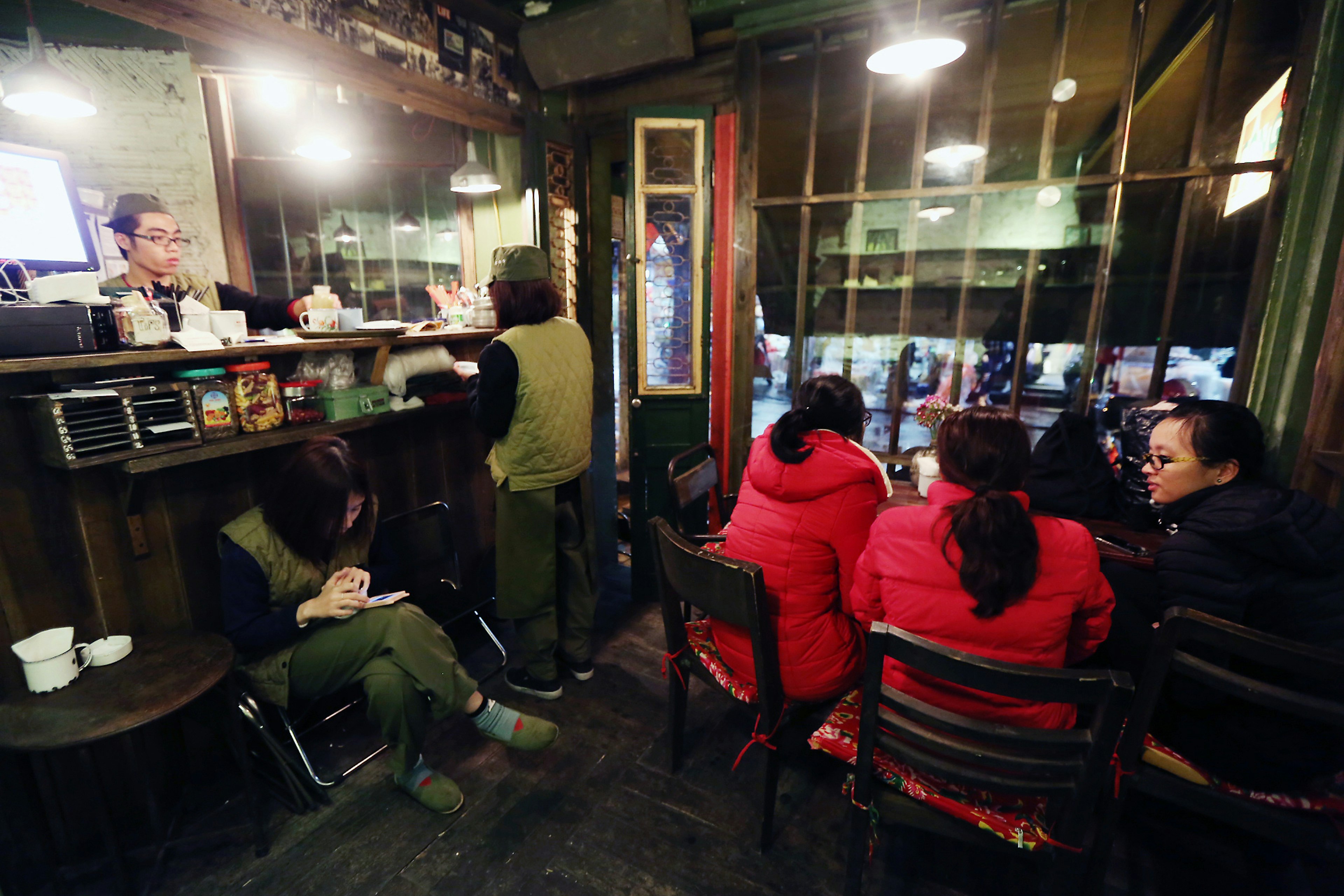 Customers sit in Cong Caphe coffee shop at night in Hanoi, Vietnam