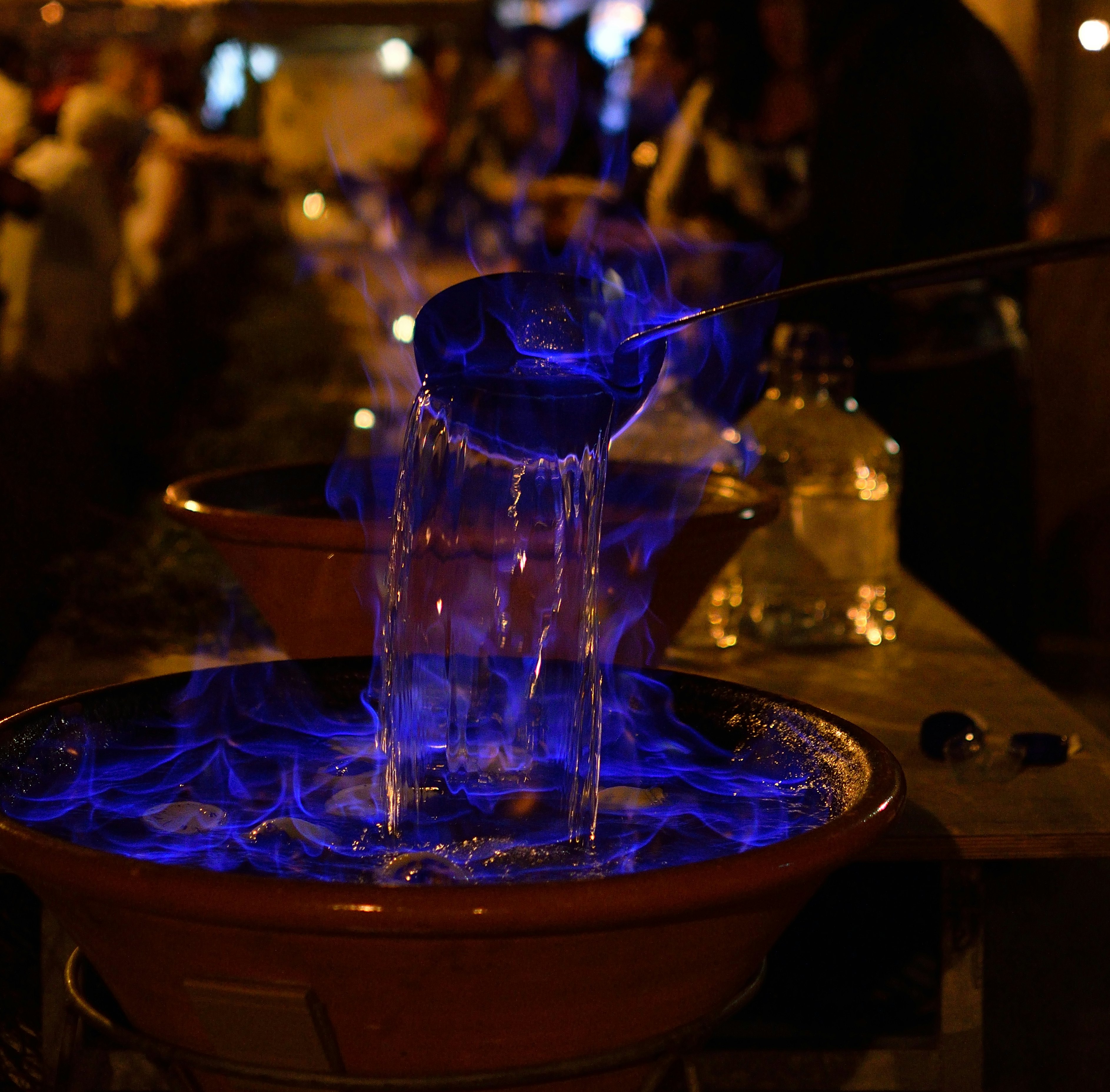 A bowl of traditional Galician queimada punch set alight in a Spanish restaurant