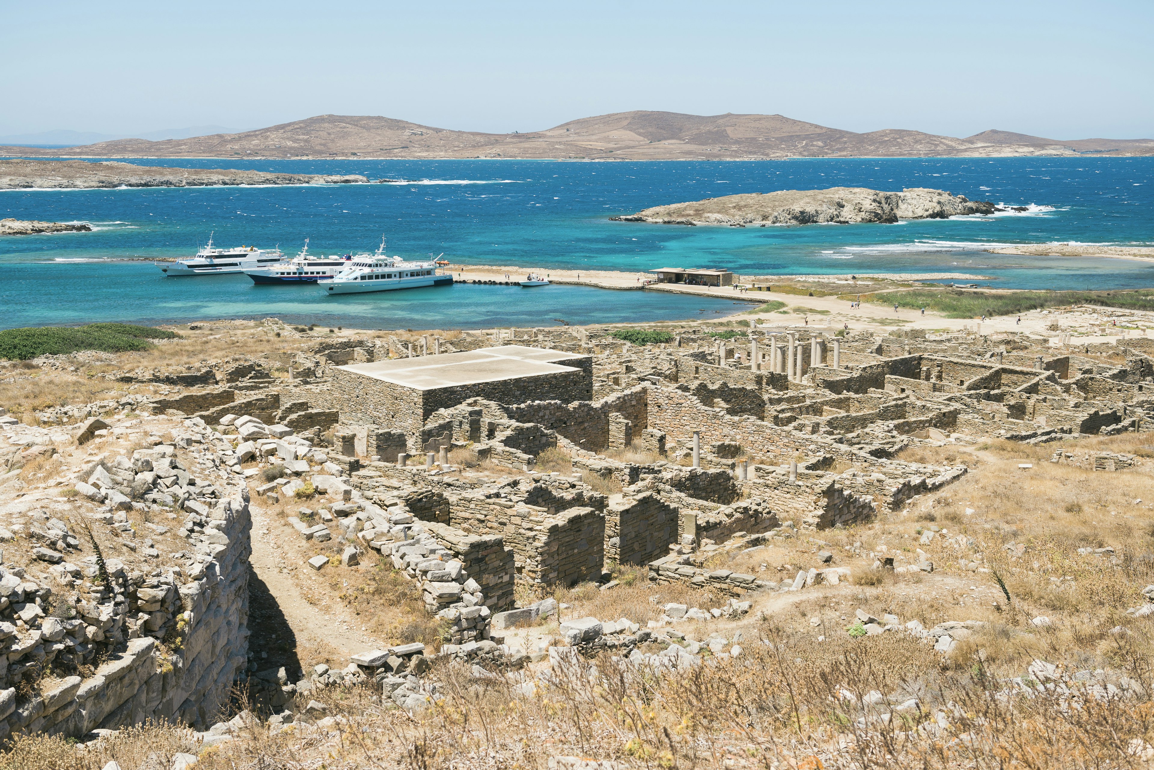 The ruins on the island of Delos overlook crystal blue water.