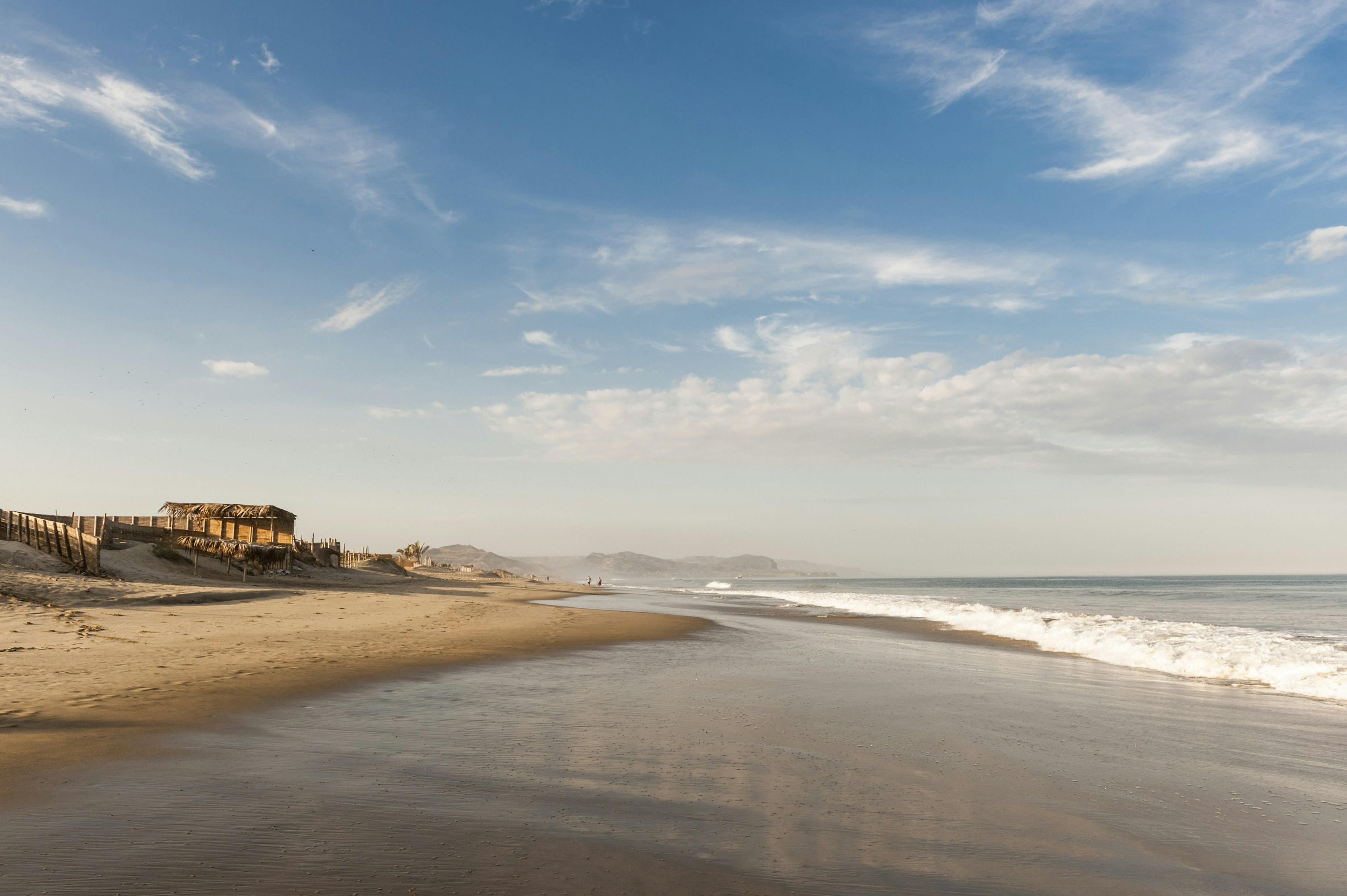 View of coastline with golden sand and blue sky