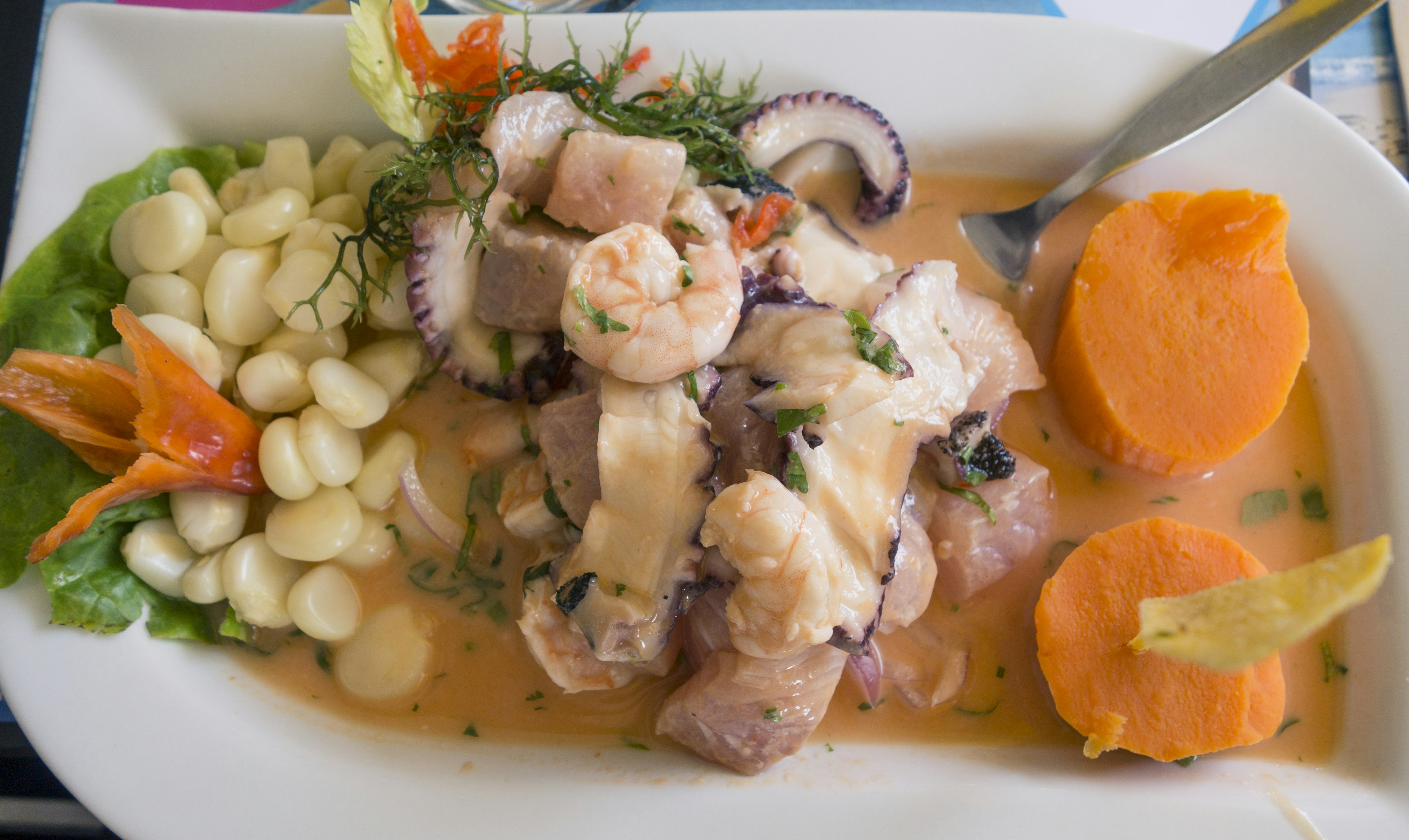 Fish, shrimp, and octopus in a mixed ceviche served with corn at a restaurant in Lima, Peru