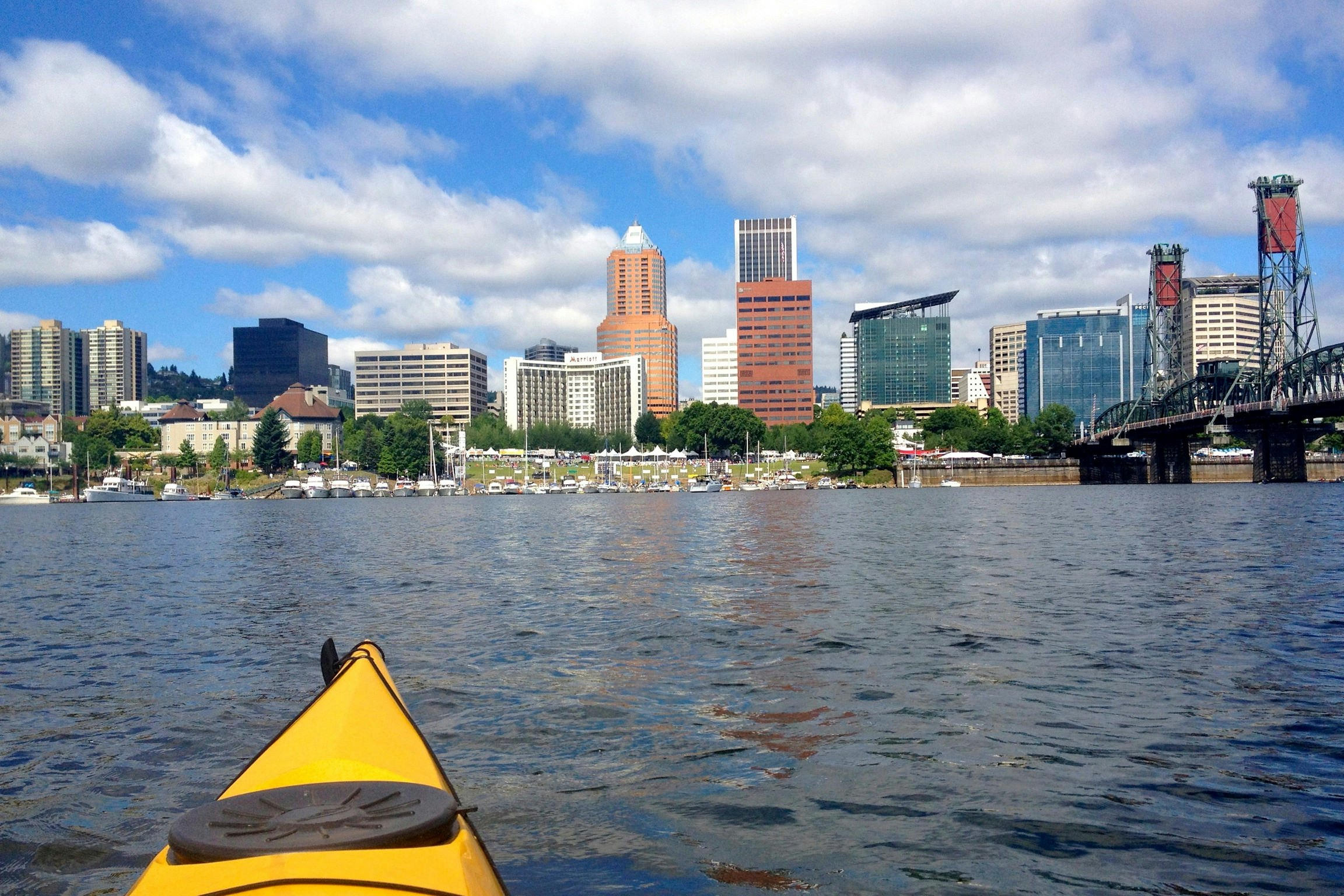 A kayak on a river pointing towards a CBD with high-rise buildings