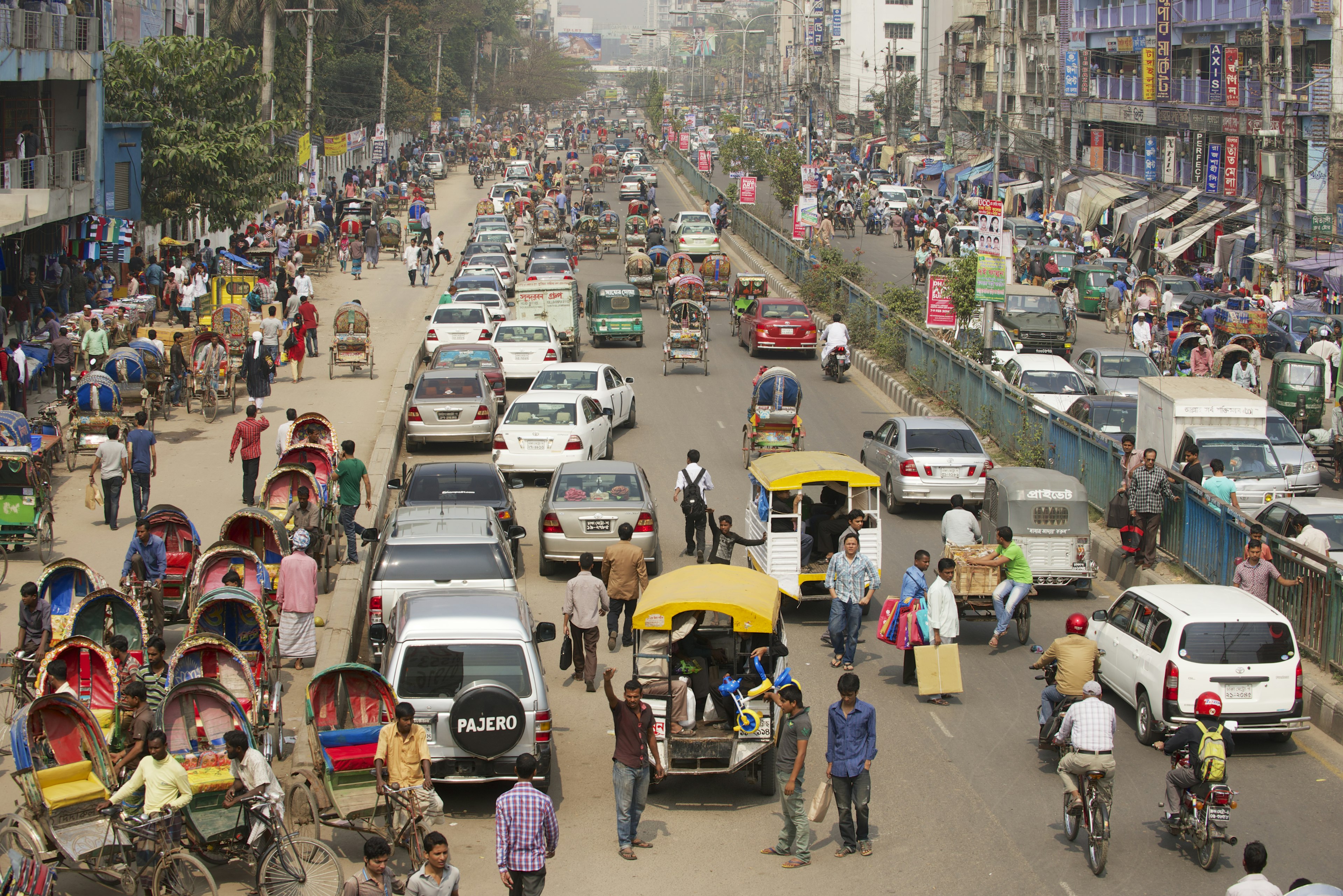 Busy street congested with traffic and pedestrians in central Dhaka.