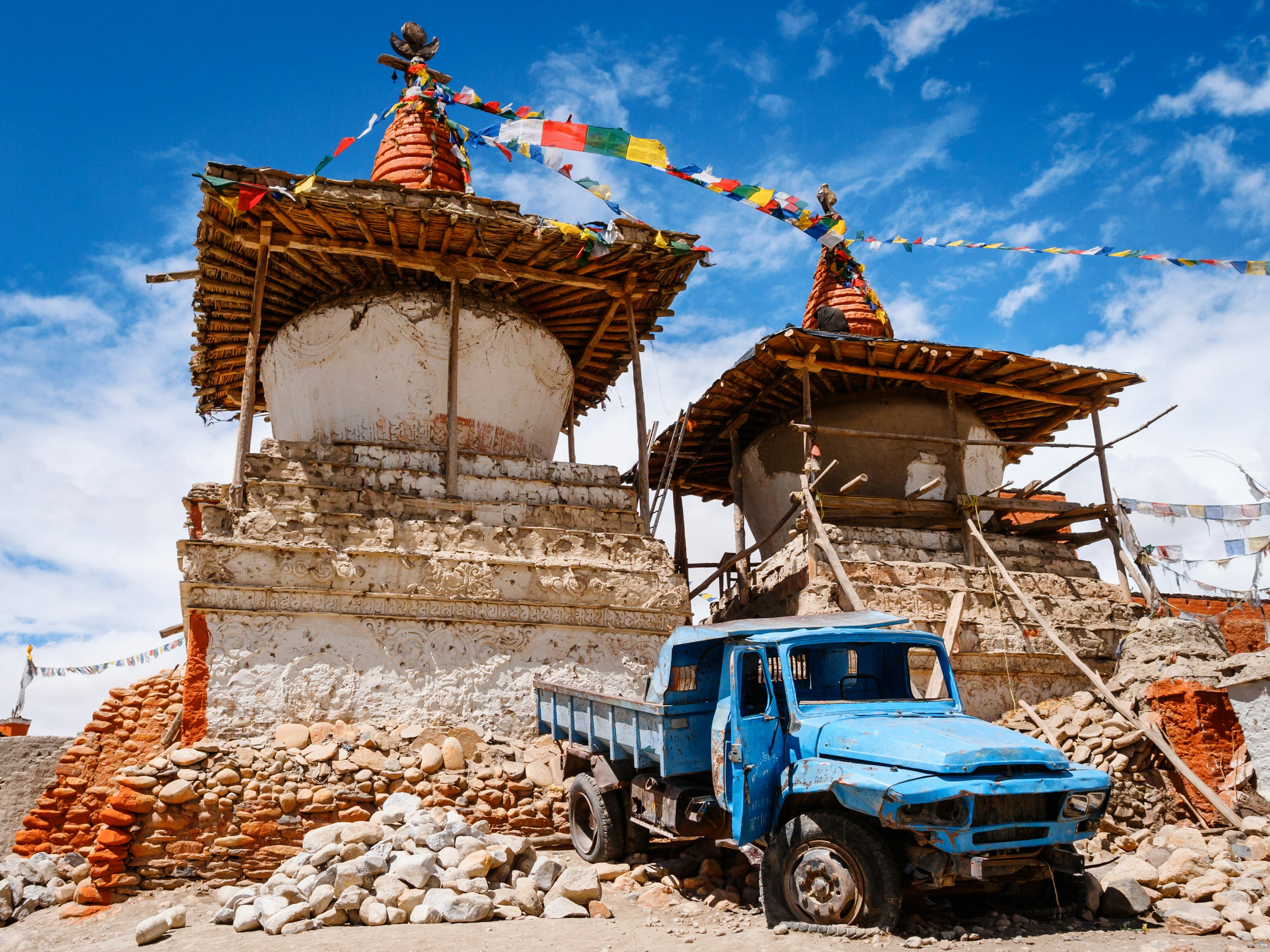 A wrecked blue Chinese truck sits in front of ancient Tibetan Buddhist chortens (stupas) that are under restoration in Lo Manthang, close to the Tibetan border of Nepal.