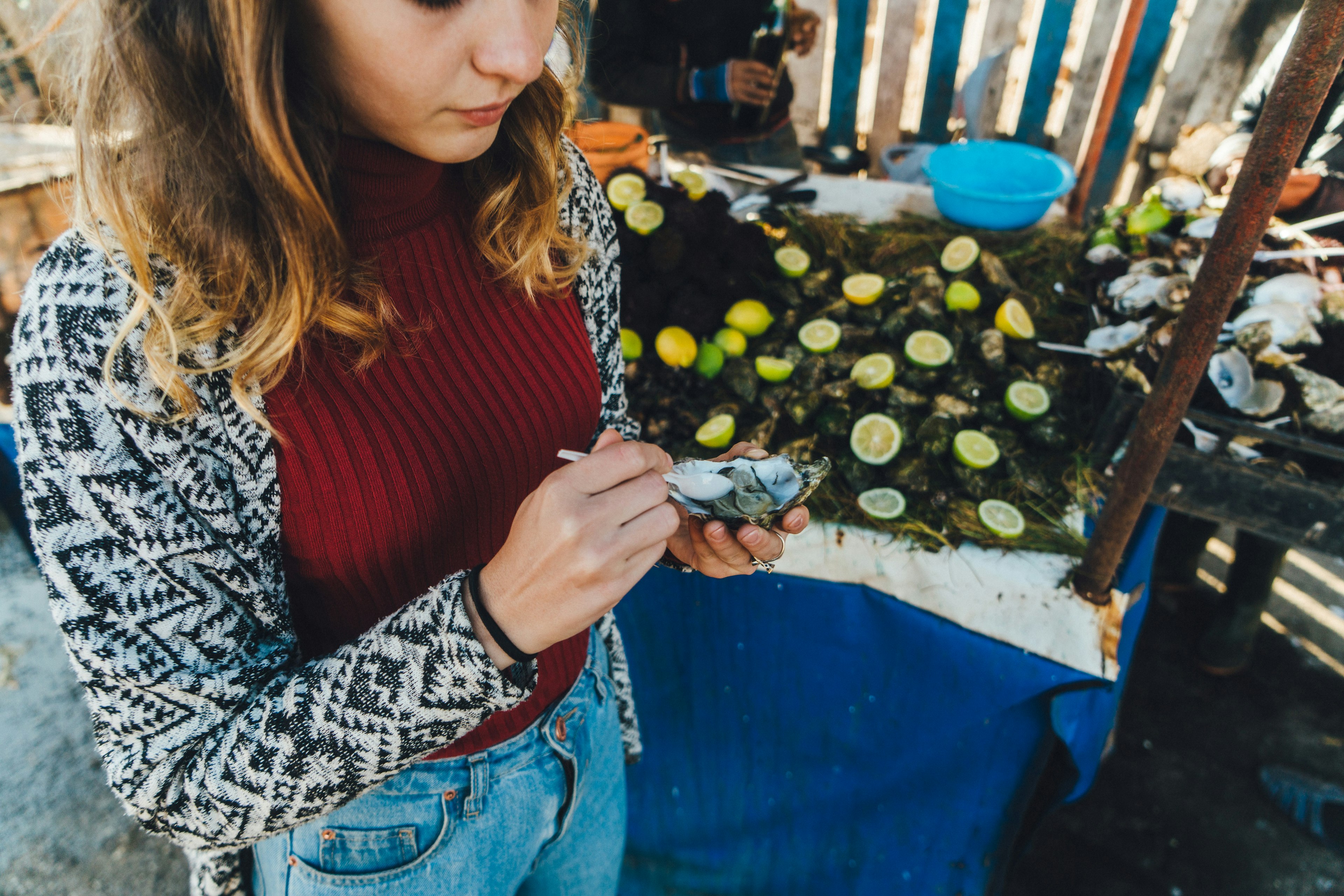 Woman eating an oyster in the Port of Essaouira, Morocco.