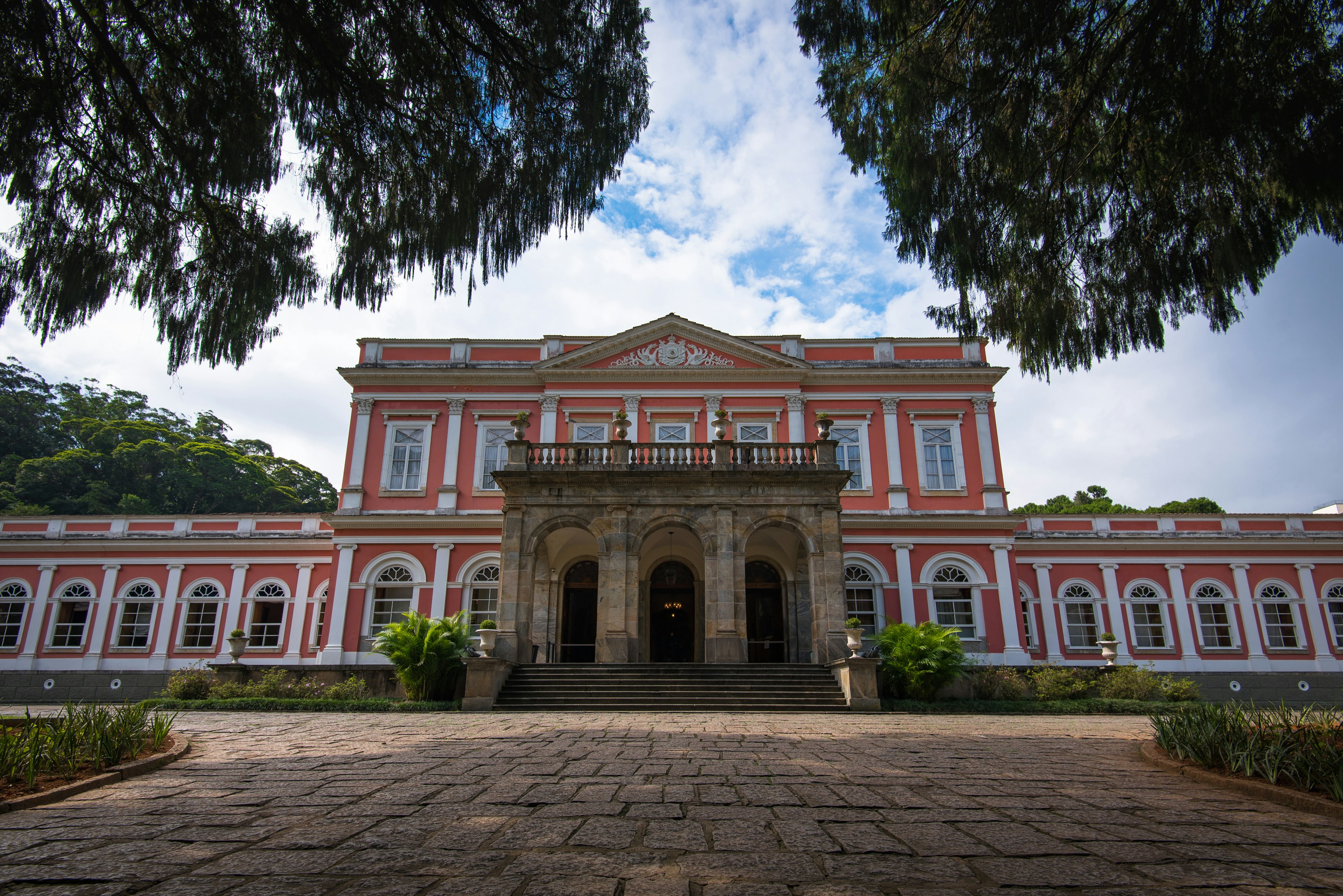 Ground-up view of a large pink mansion.