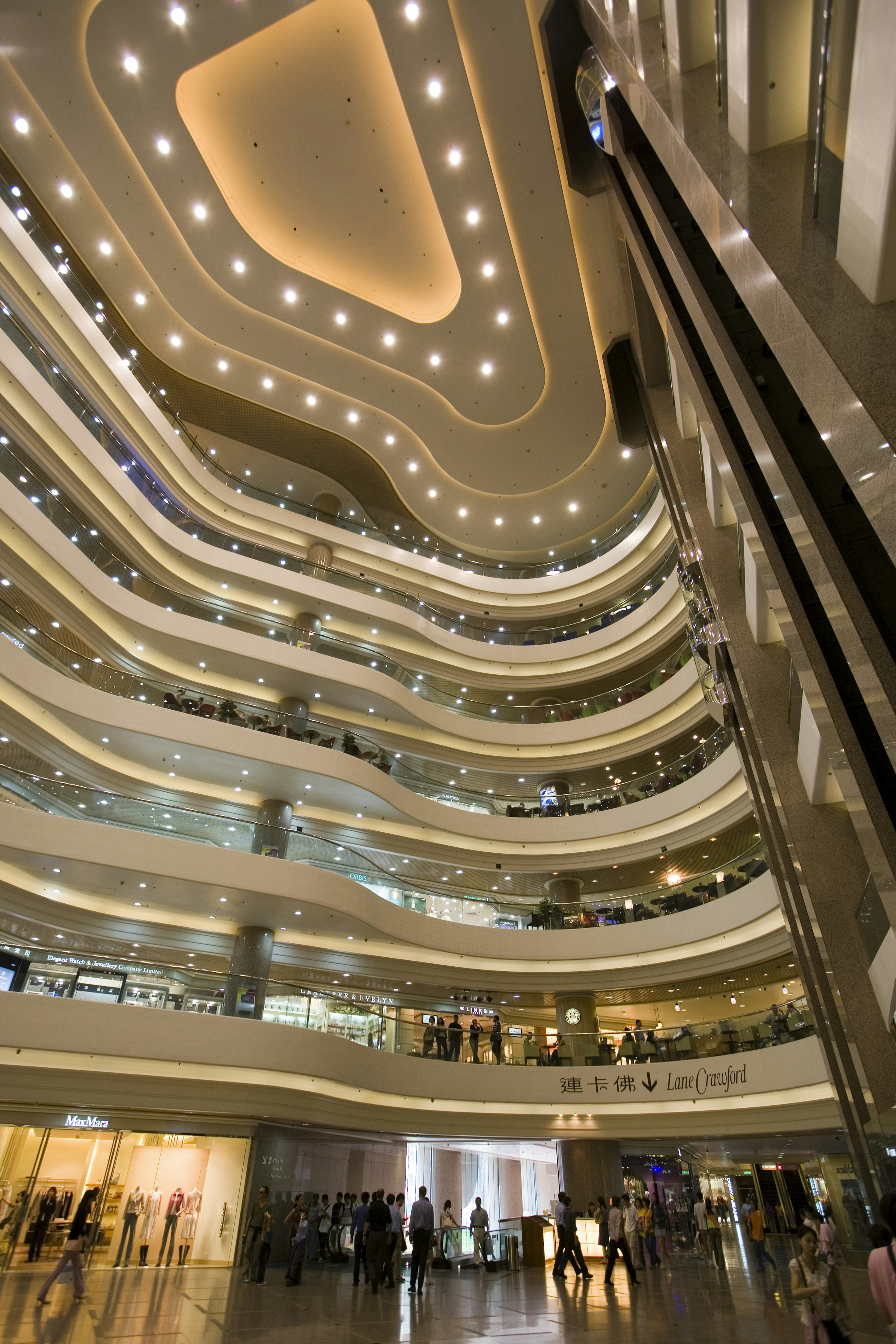 A view of a well-lit, tiered atrium with seven stories at Times Square Mall, Hong Kong.