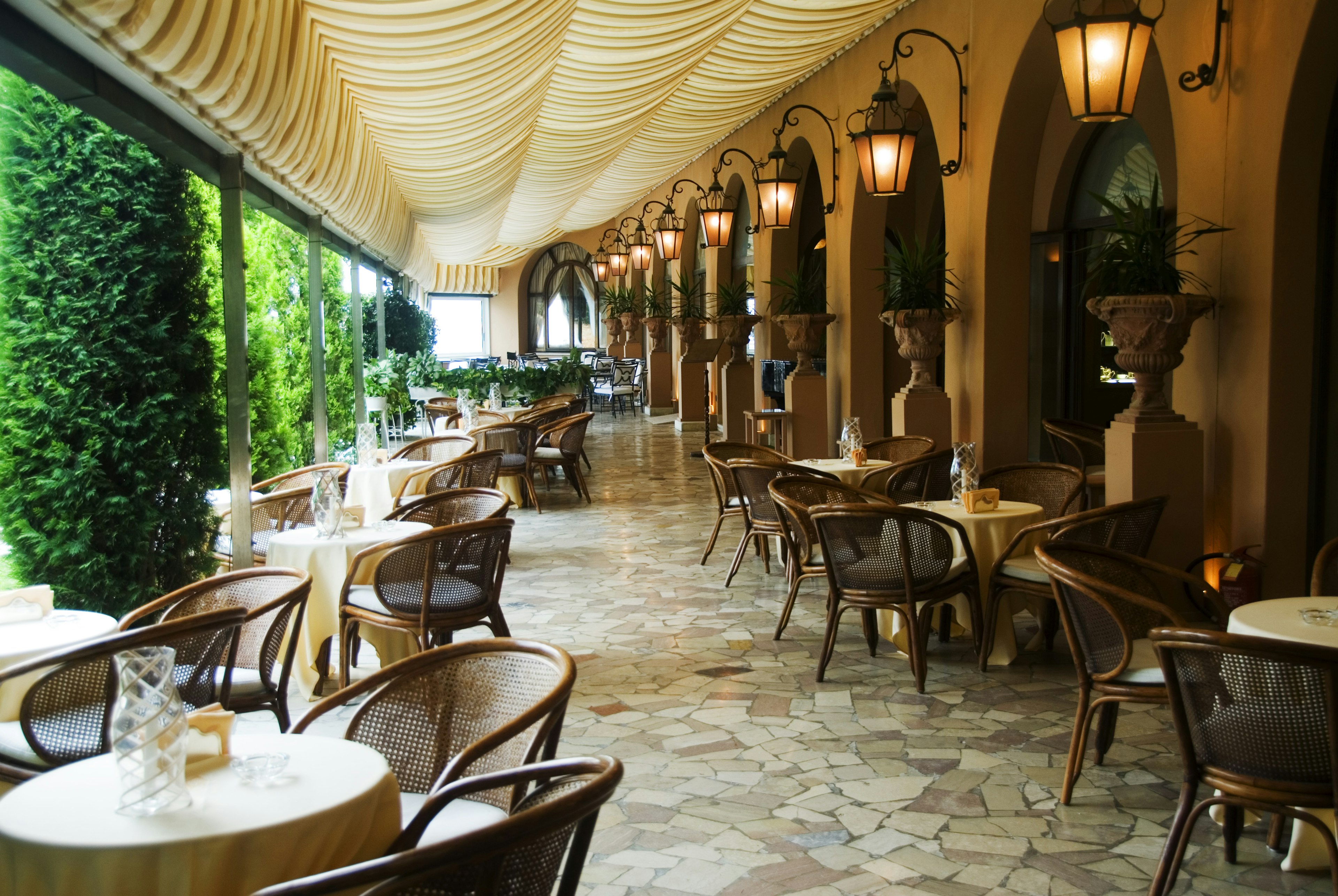 A covered outdoor terrace dining room, empty of people.