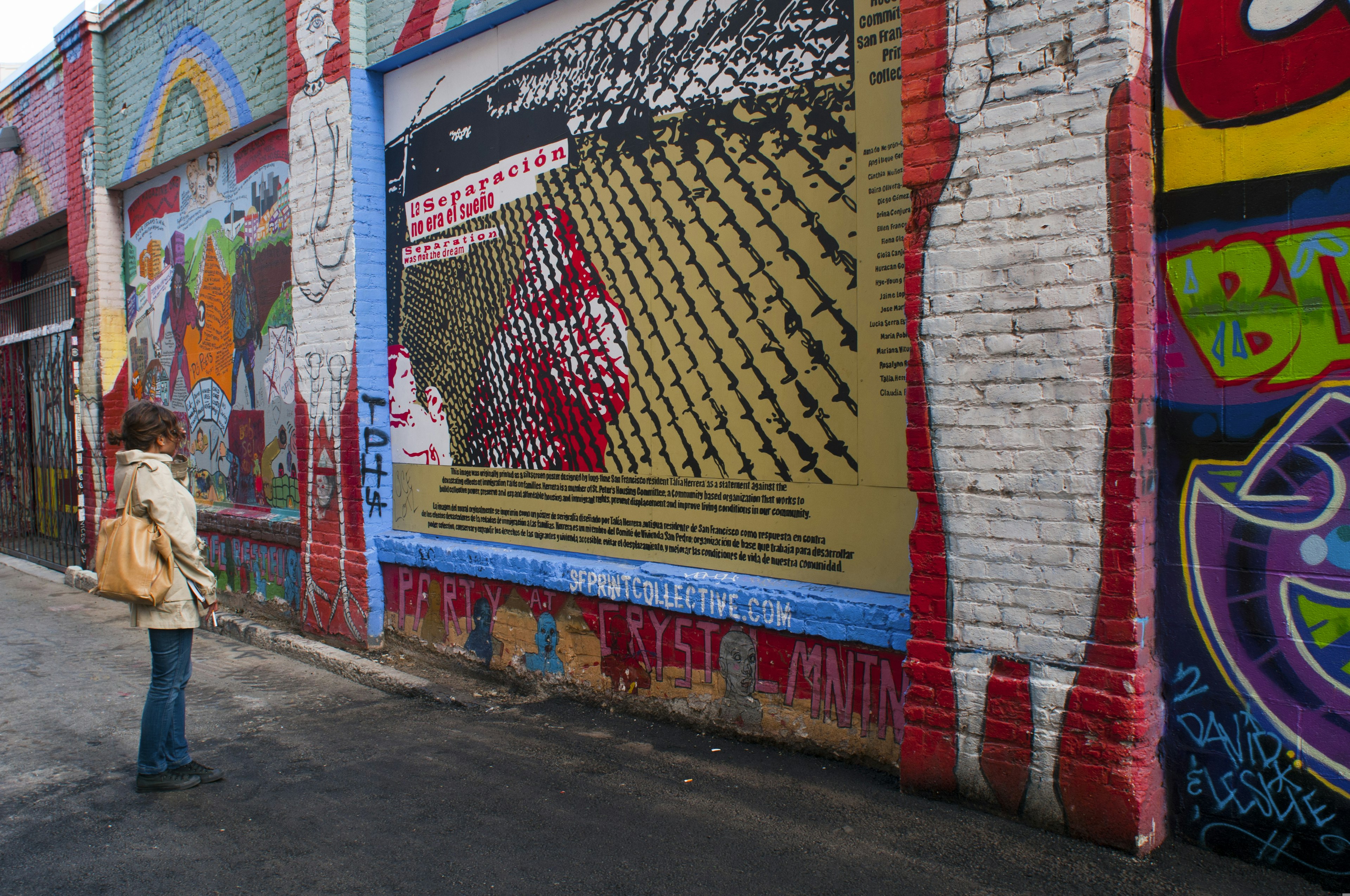 A woman stops to look at the colorful murals in Clarion Alley in the Mission neighborhood, San Francisco, California, USA