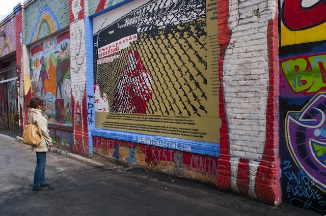 A woman stops to look at the colorful murals in Clarion Alley in the Mission neighborhood, San Francisco, California, USA
