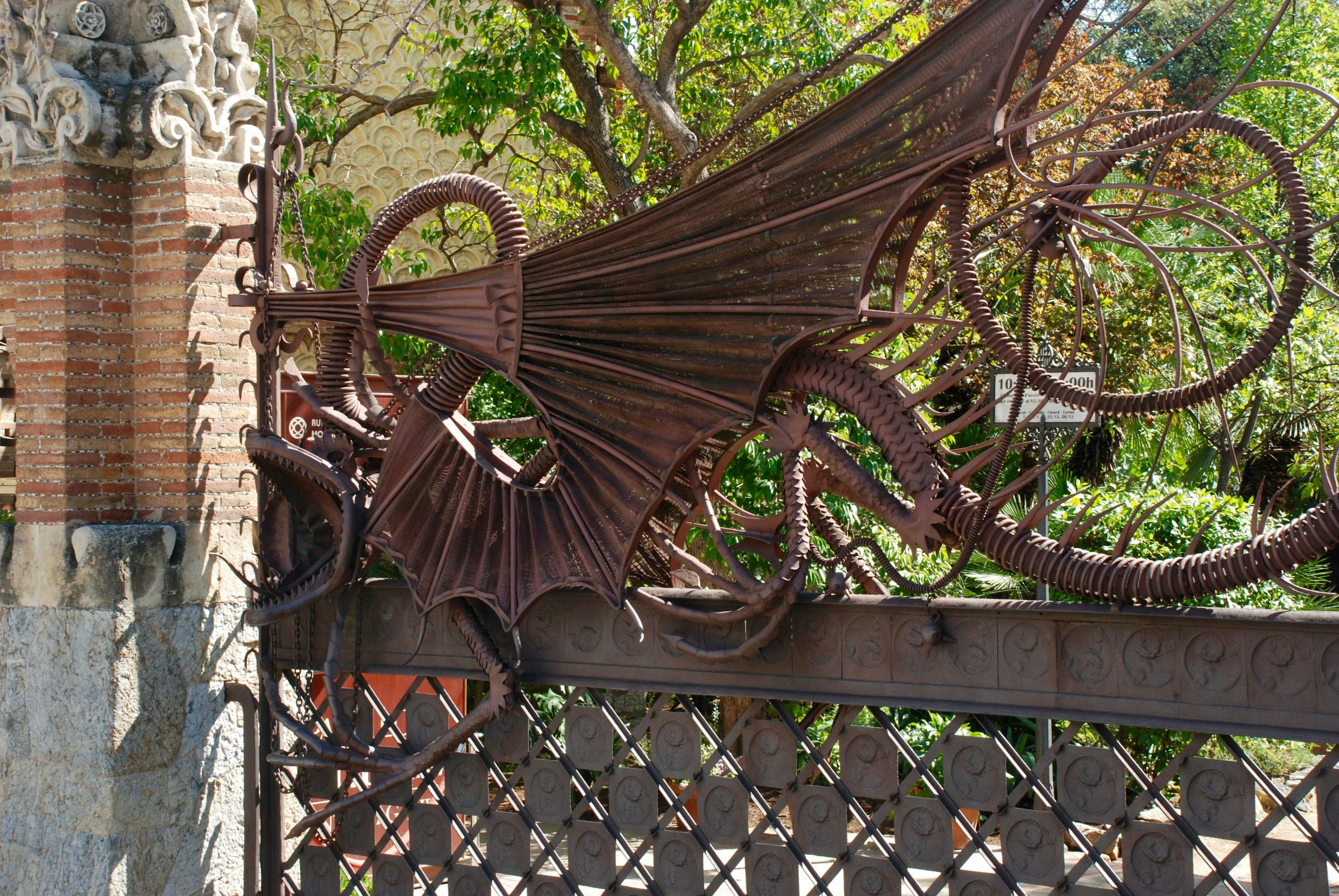 A close-up of Gaudí's intricate, fantastical wrought-iron dragon gate, embellished with likenesses of dragons.