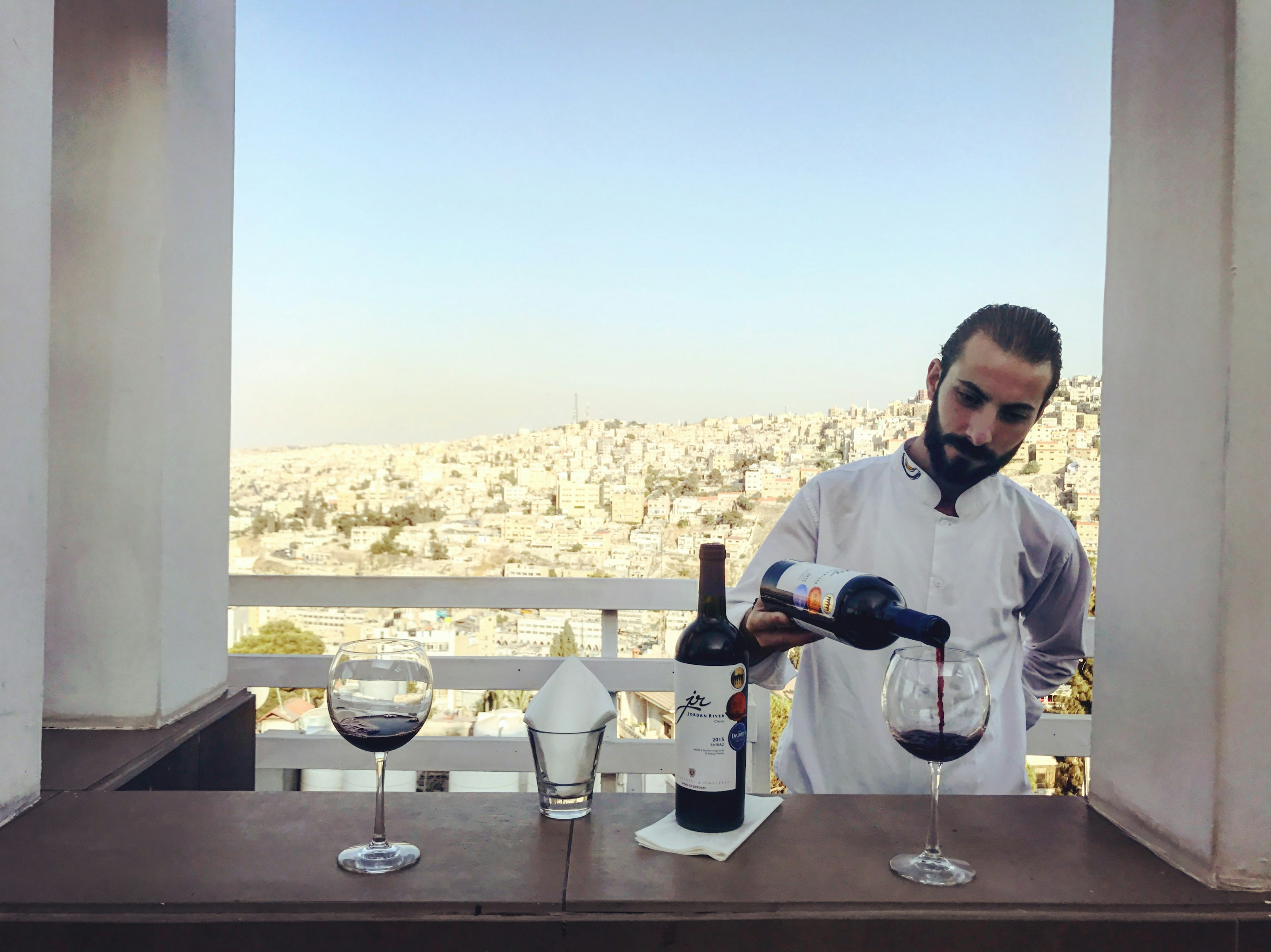 Local Jordan River Shiraz with a view of Amman from Cantaloupe's upper terrace