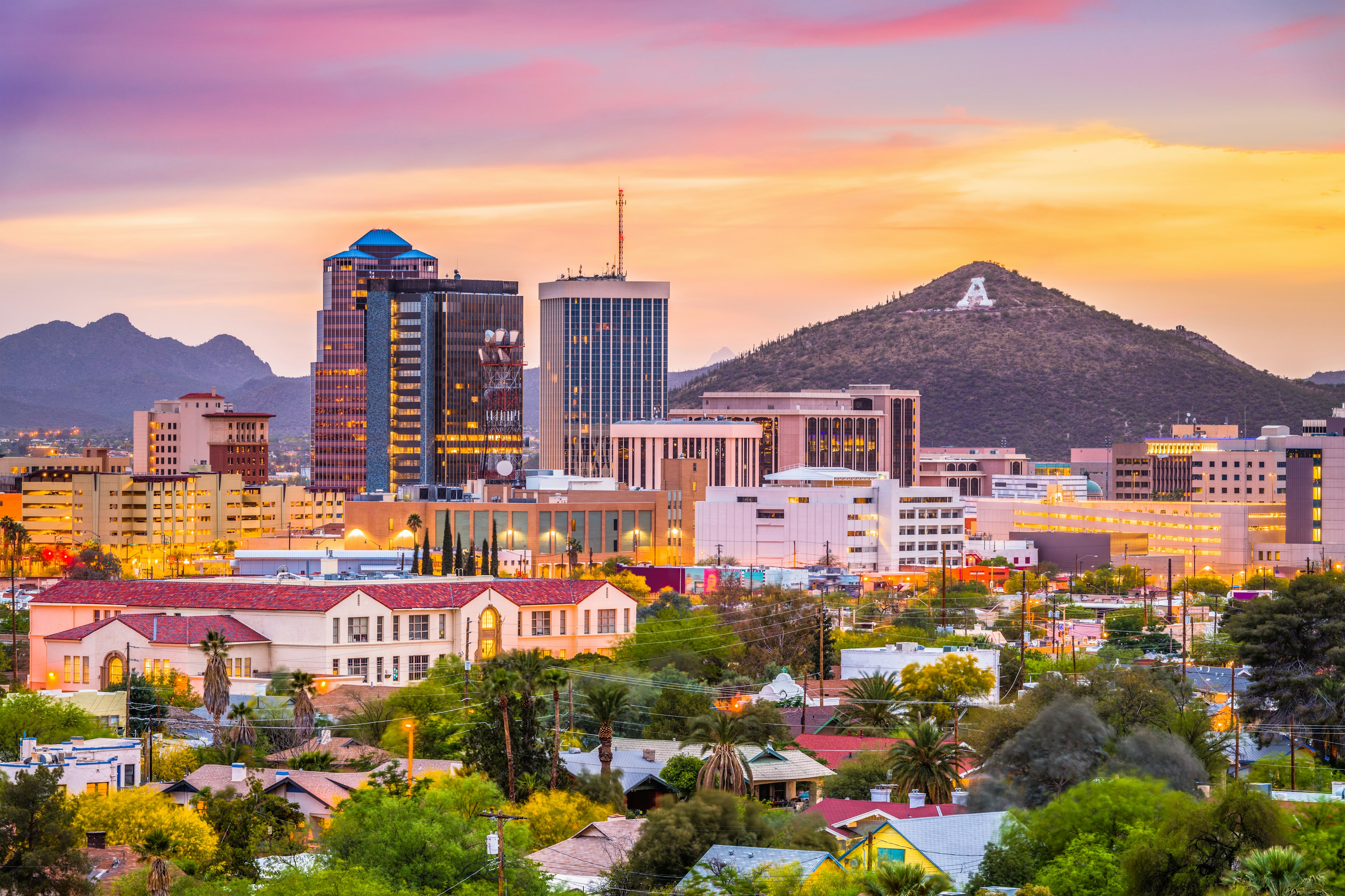 At dusk, a skyline view of Tucson, Arizona with Sentinel Peak in the background.