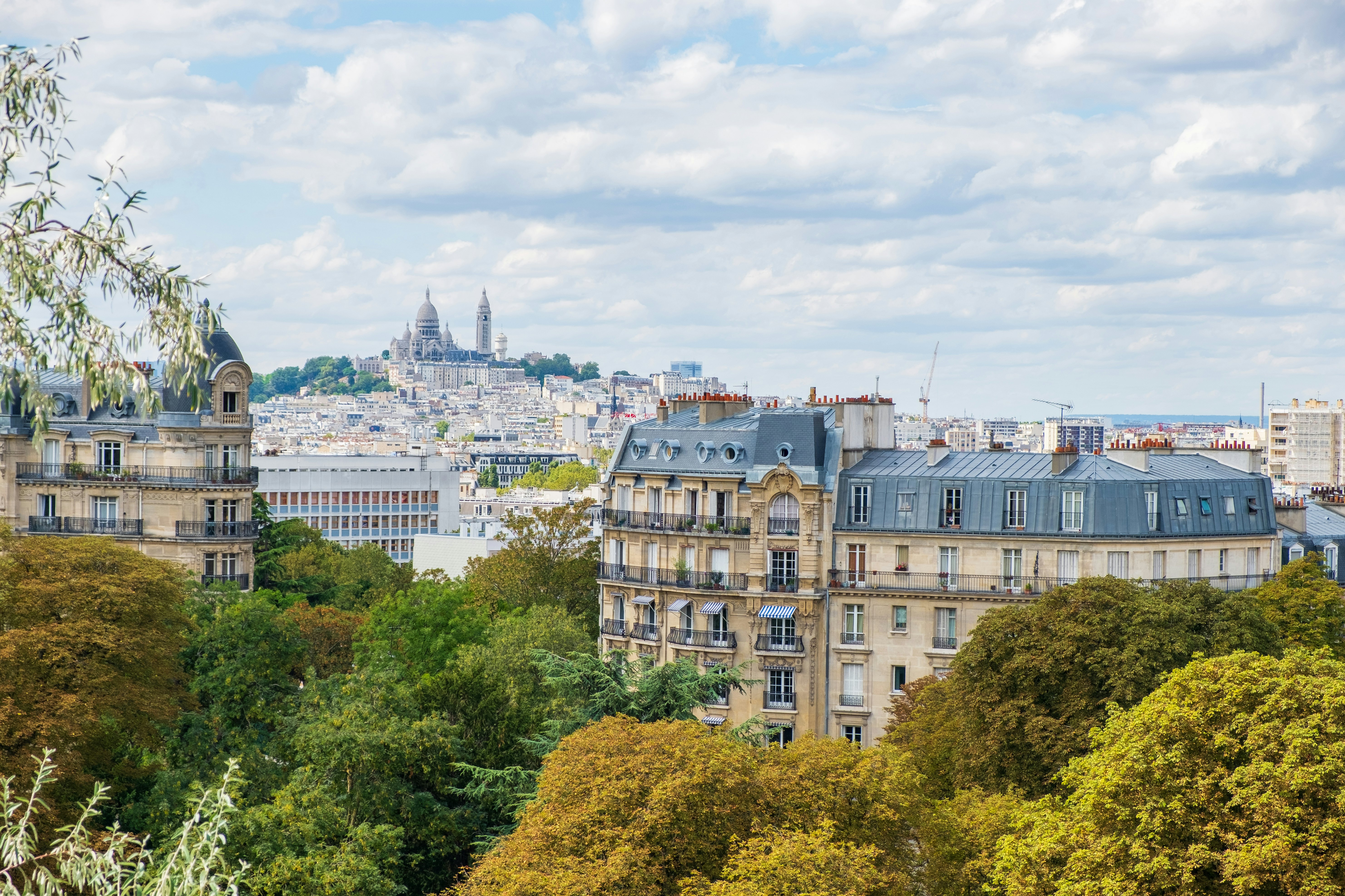 Paris skyline with Montmartre hill and Sacre Coeur Basilica viewed from Buttes-Chaumont Park.