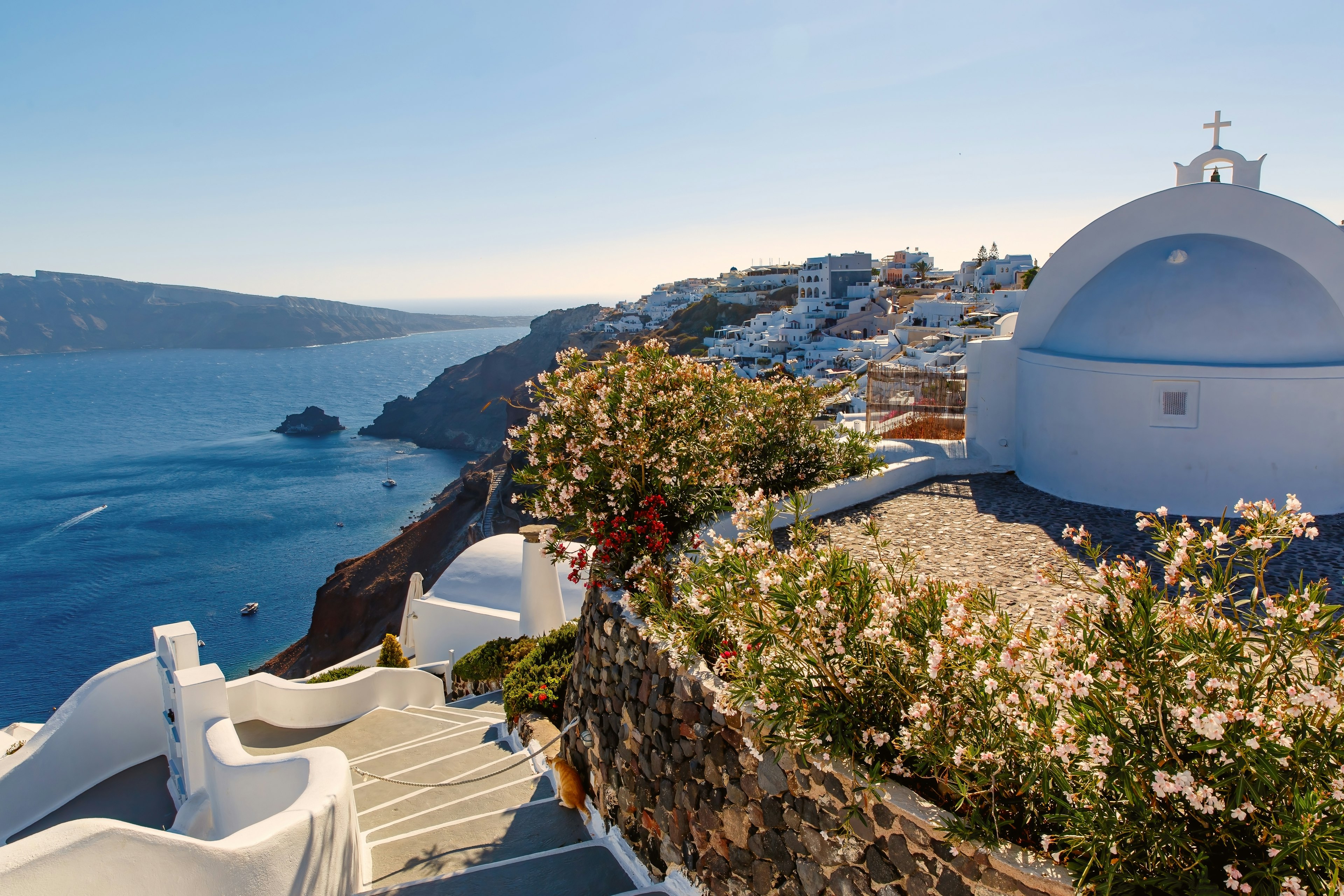 The blue and white facades along Santorini jagged coastline offer sweeping views of the ocean.