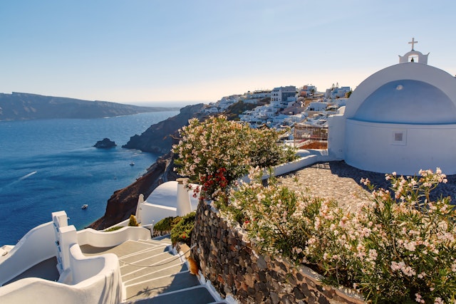 The blue and white facades along Santorini jagged coastline offer sweeping views of the ocean.