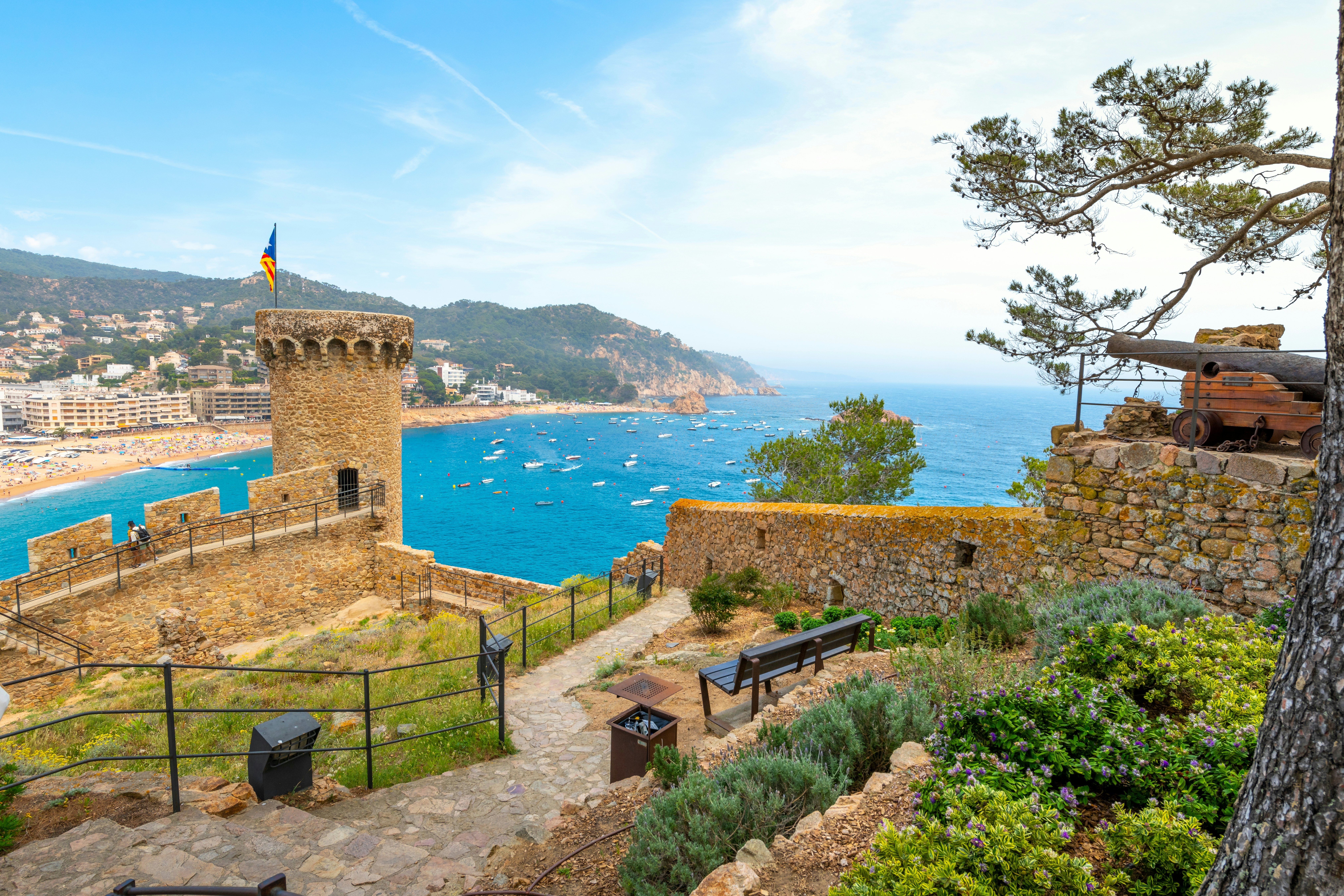View of the Mediterranean Sea and a sandy beach from the medieval hilltop 12th-century castle in Tossa de Mar, Spain, along the Costa Brava coastline.