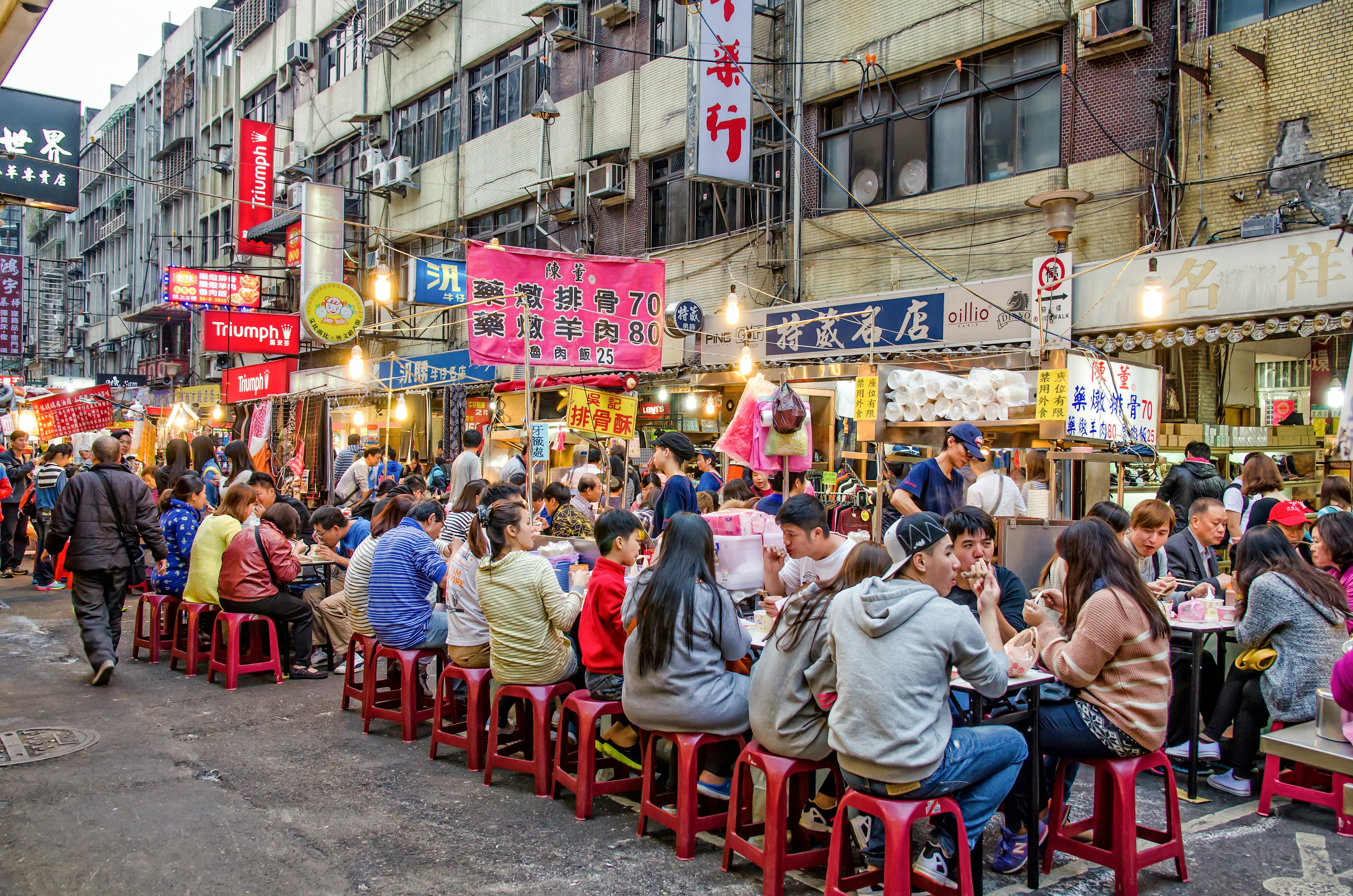 In the streets of Taipei, Taiwan, long tables are filled with people eating at the city's Raohe Street Night Market.