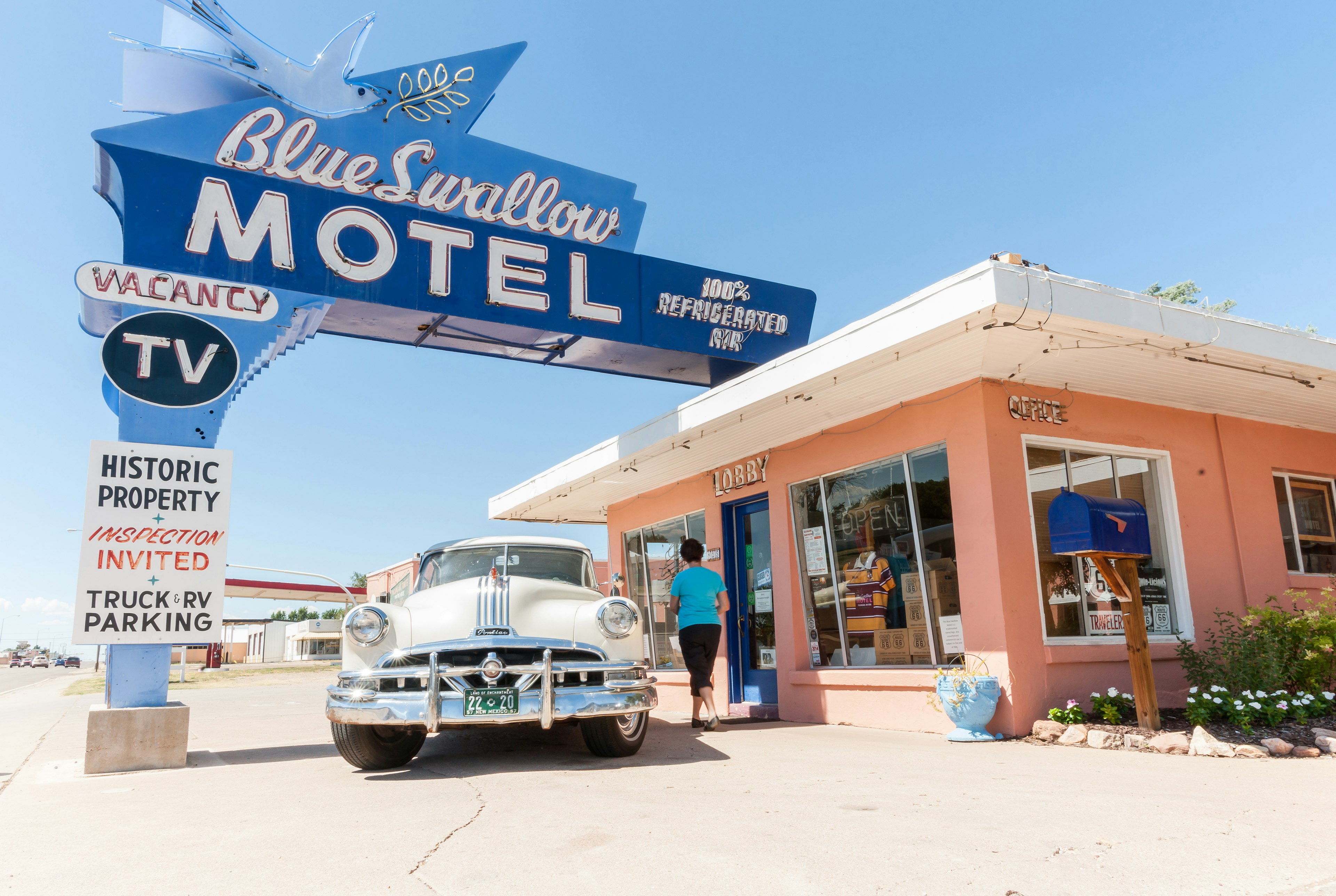 A tourist in a classic cars stops at a motel at Tucumcari on Route 66 in New Mexico.