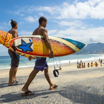 RIO DE JANEIRO - APRIL 3, 2016: Young carioca Brazilian surfers walk with surfboards from Arpoador, the popular surf point, toward Ipanema Beach. License Type: media Download Time: 2023-05-20T15:25:00.000Z User: claramonitto Is Editorial: Yes purchase_order: