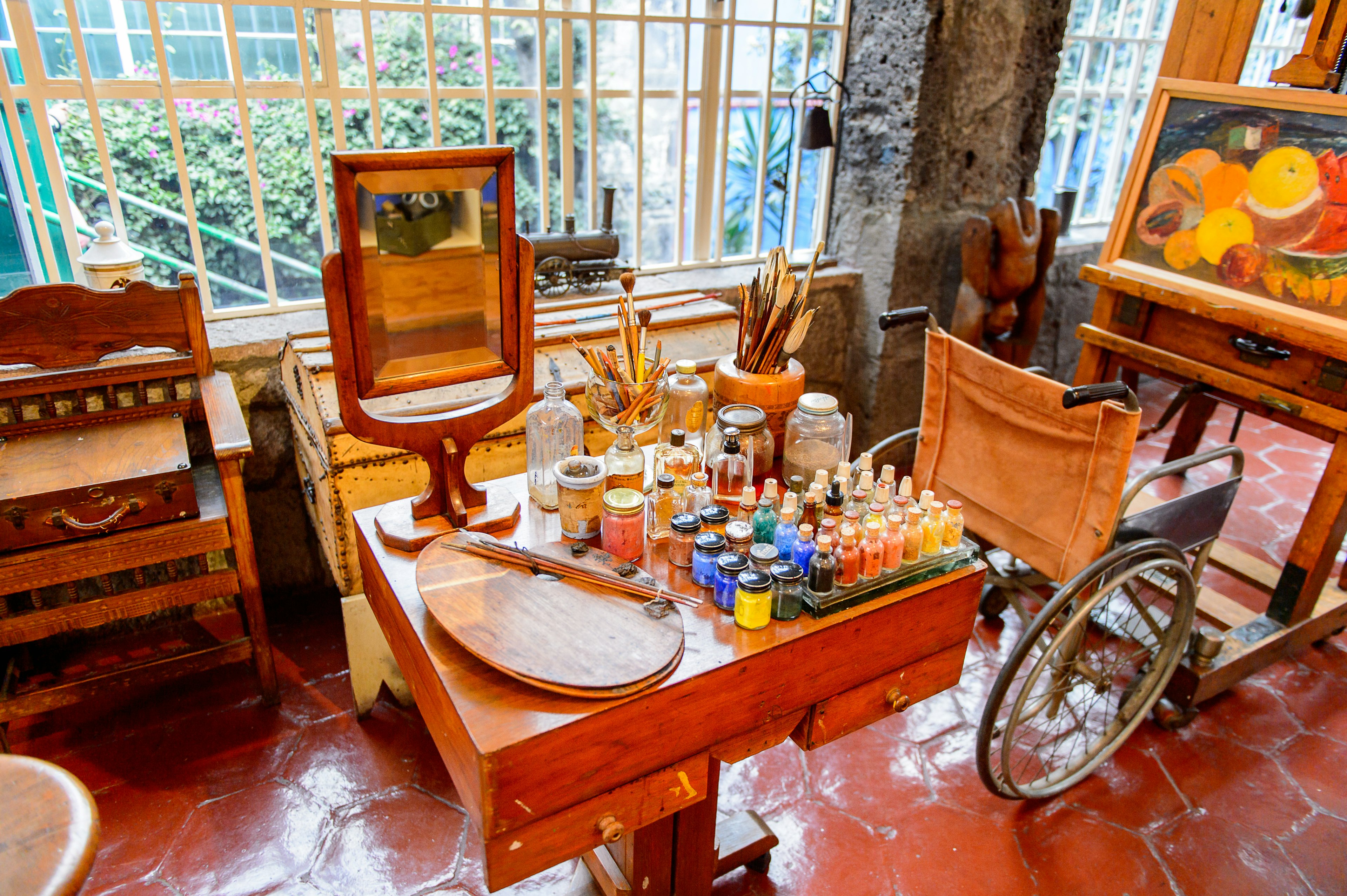 Various paints, brushes and other supplies adorn a desk