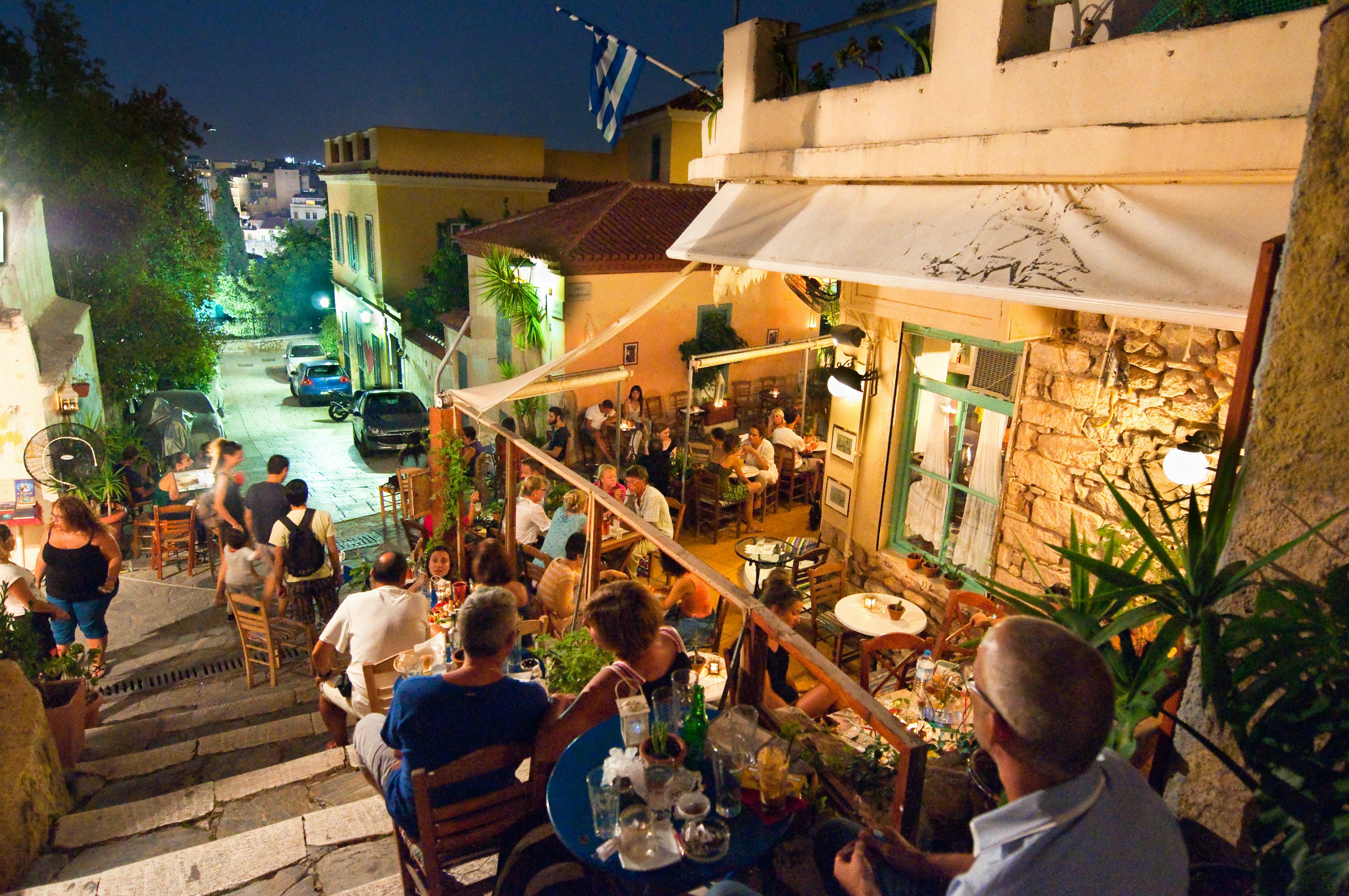 In the Plaka district of Athens, Greece the street is filled with various restaurants and bars, as locals and tourists enjoy their meal at night.