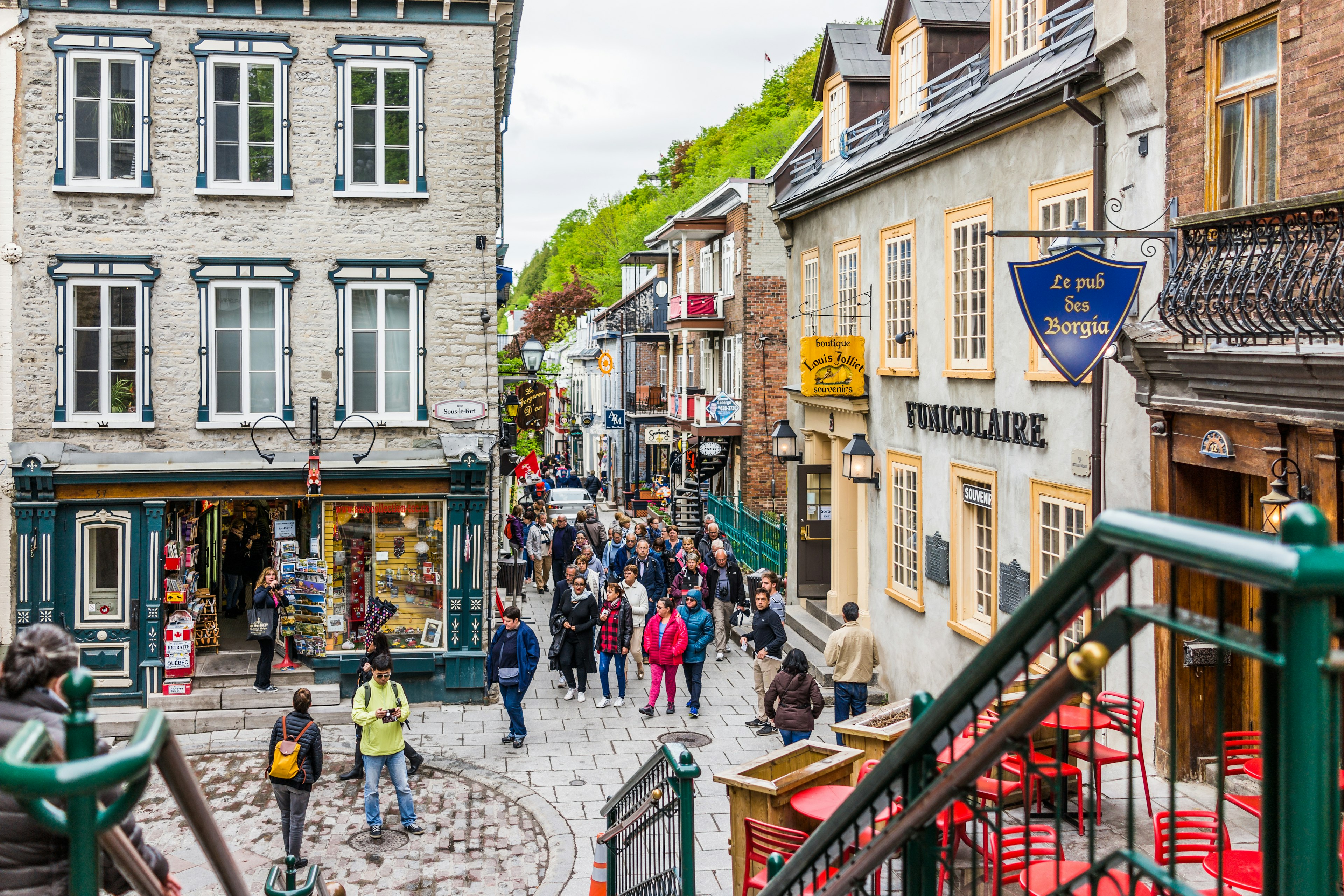 Lower old town street called Rue du Petit Champlain with Funiculaire sign and people tourists by restaurants.