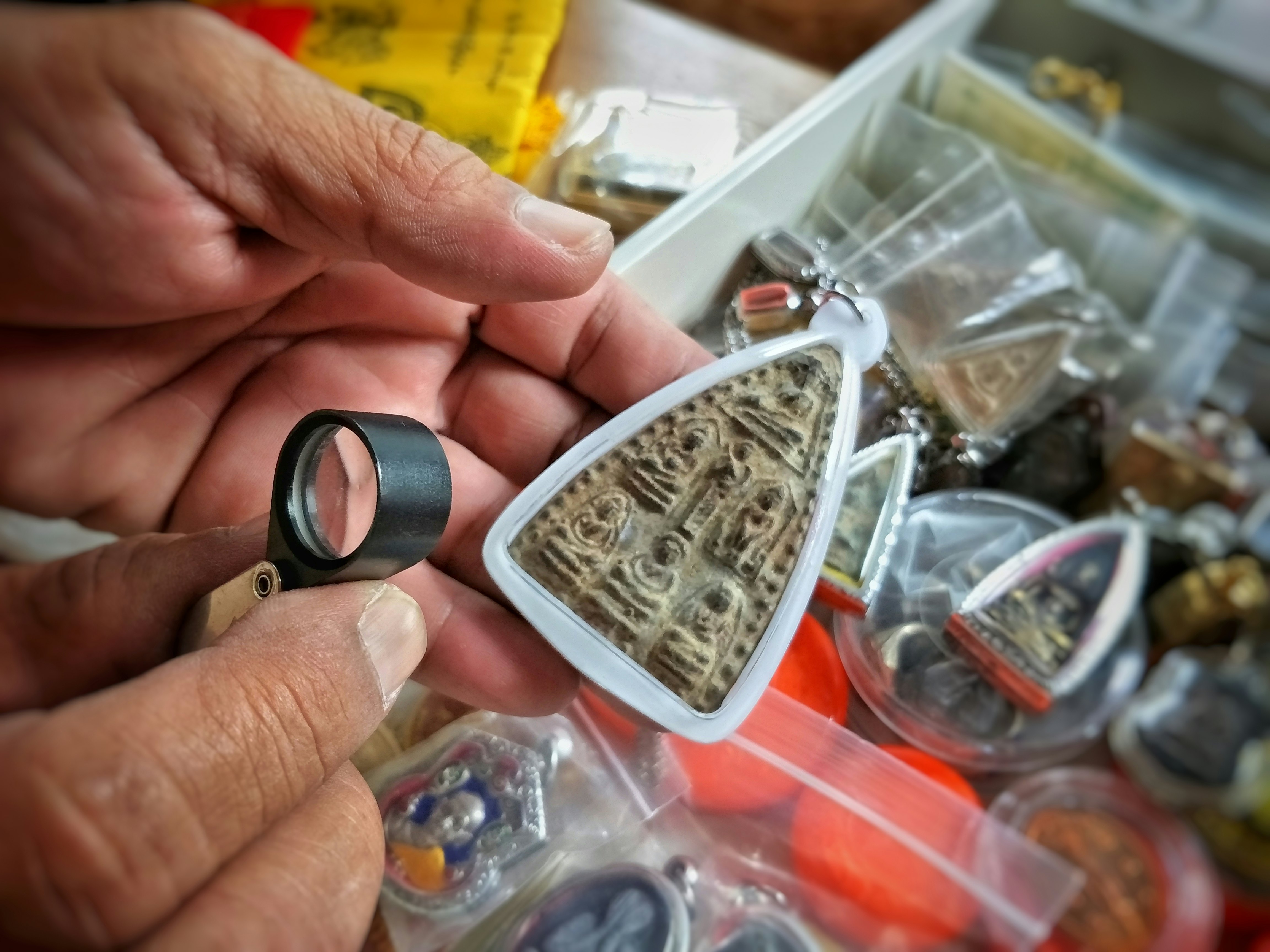 A collector inspects a votive Buddhist tablet at Bangkok's lively Amulet Market. Supanee Prajunthong/Shutterstock