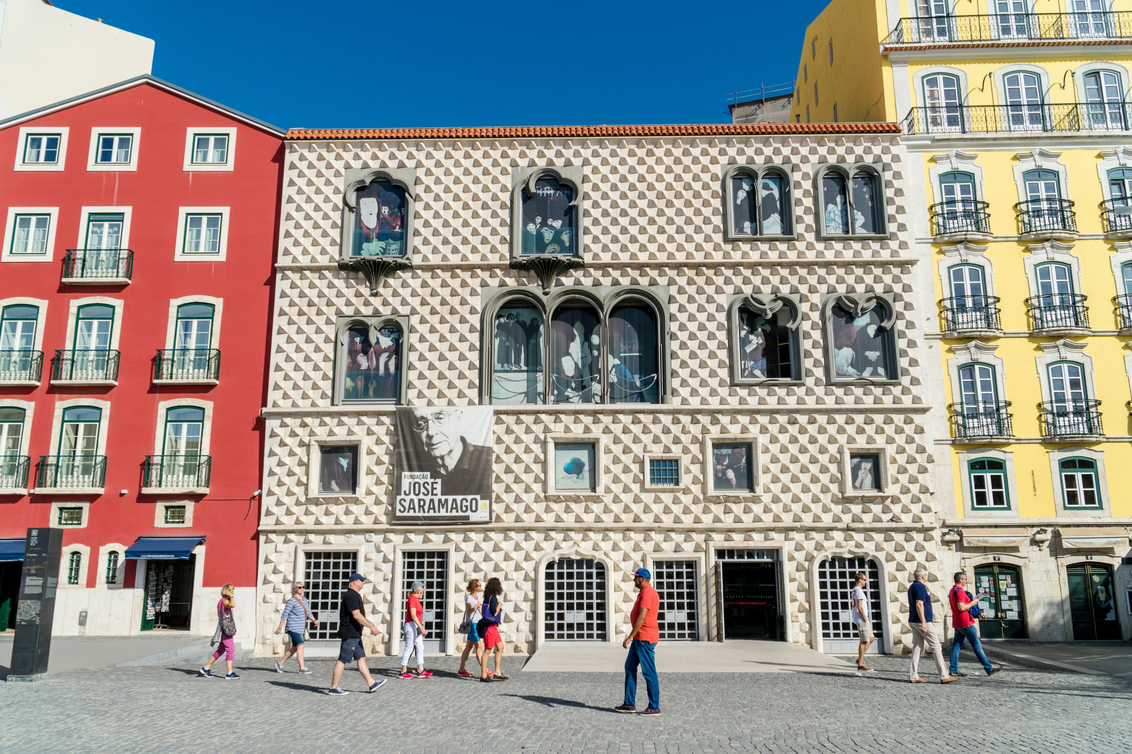 People walk by a museum building with a patterned facade