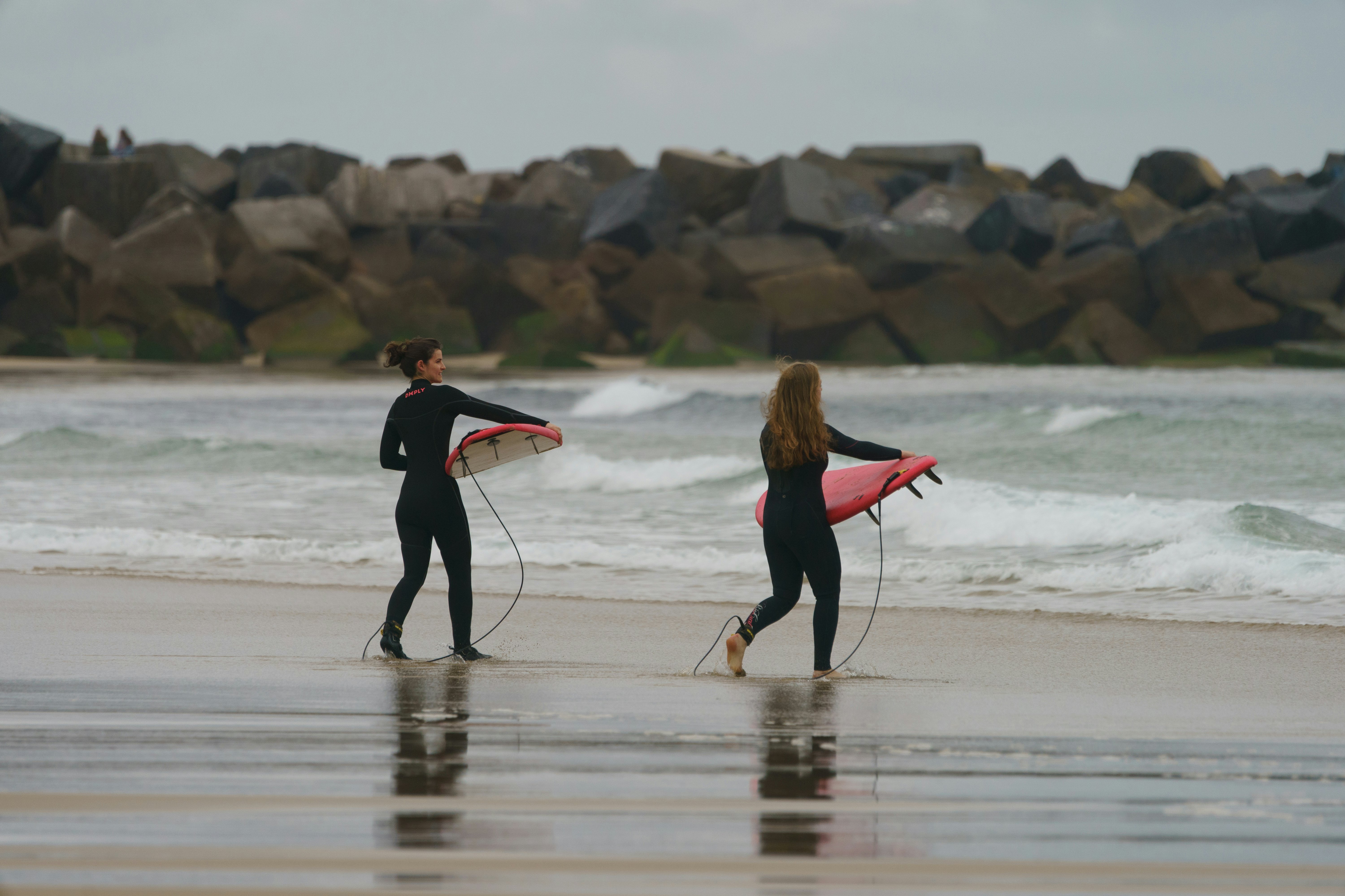 Water splashes around young surfers at San Sebastian.