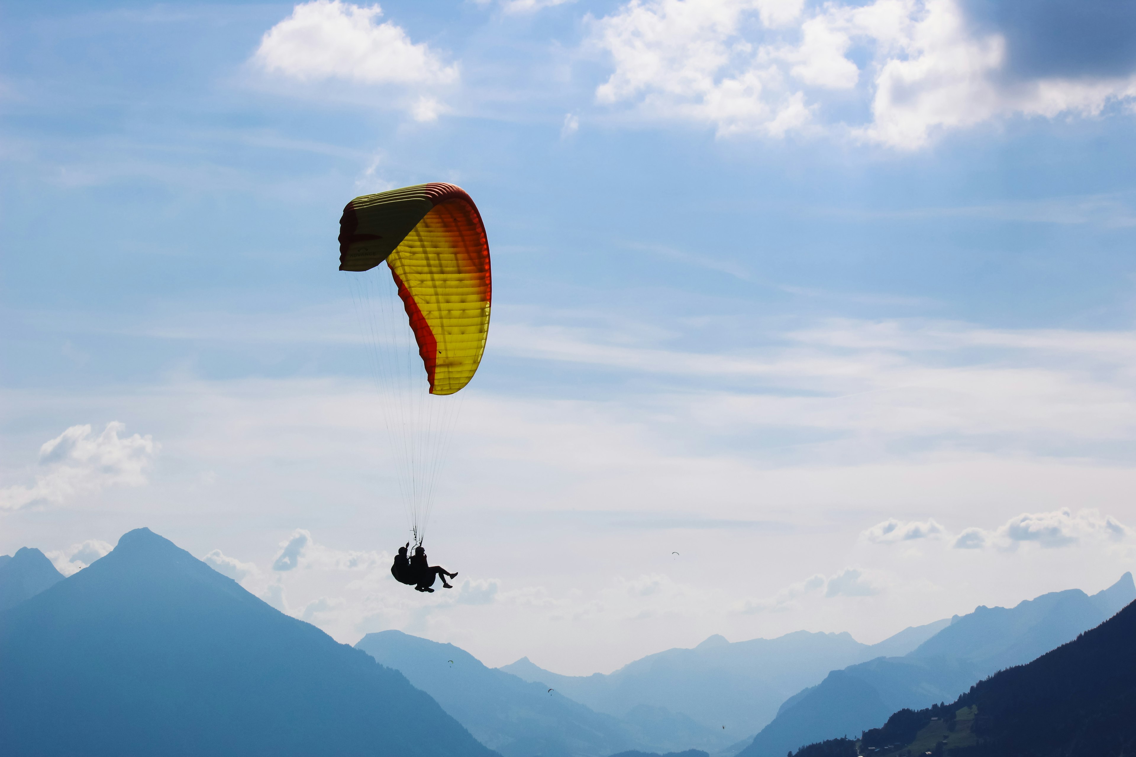 Tandem paragliding in Swiss Alps. Silhouettes of paragliders and beautiful mountains. Extreme sport, adventure sports.